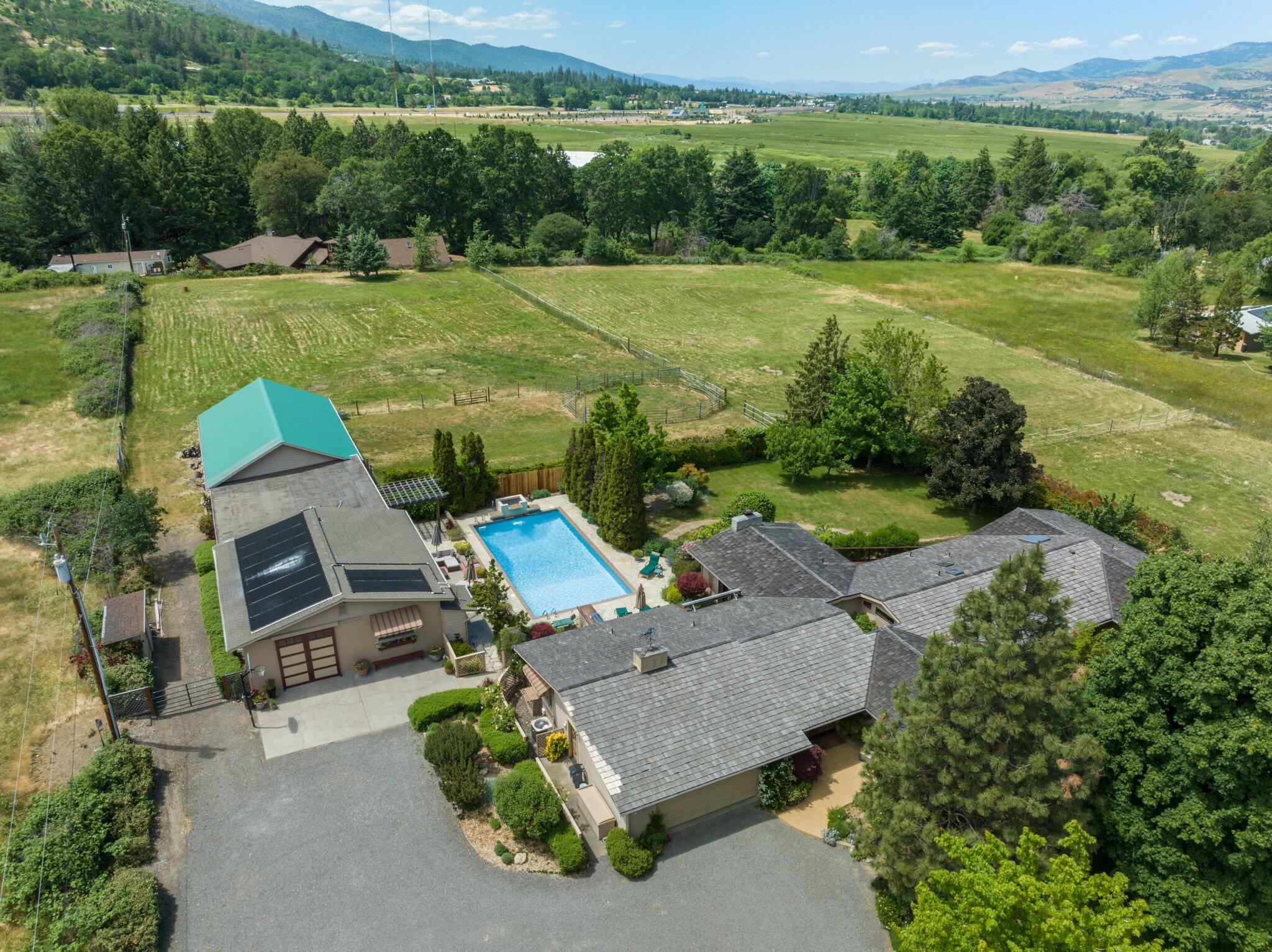 Single level 5 bd 5 bth, 5 acre EFU, irrigated & crossed fenced horse property has everything! Lrg wood French door entry.  Slate tile, reclaimed RR tie, carpet flooring. Living room & family rooms with gas fireplaces and a wet bar. Delightful kitchen with high end appliances.  Office. Laundry/mud room.  Courtyard with water feature. Lrg primary with both a walk in closet and custom closet in bath.  2 bedroom attached ADU with fireplace. Large deck. Outdoor kitchen next to large inground pool with its own changing rooms/shower. Detached 1 bd ADU with kitchenette.  Tack room, 5 stalls, horse wash, and hay loft. TID water rights. New HVAC. Central vac. Hot tub ready. New Fire-retardant cedar shake roof. Beautifully landscaped and gated.