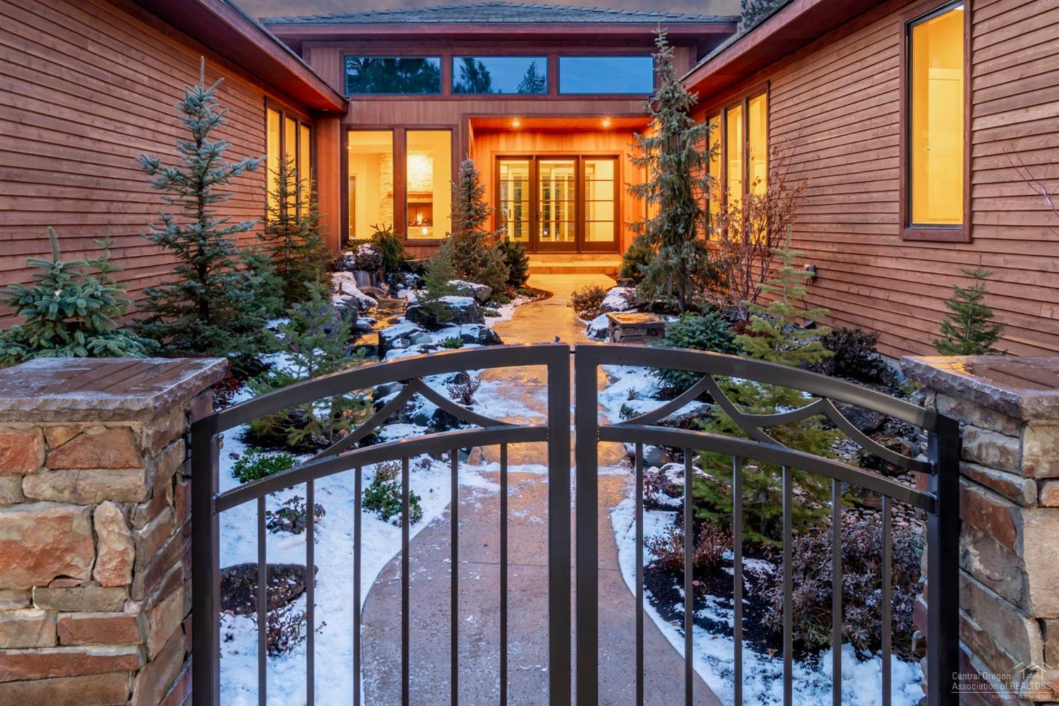 Newly constructed SINGLE LEVEL home combines a blend of Modernist contemporary architecture with classic northwest style. Behind gated courtyard walls & nestled within nearly 1/2 acre sanctuary, waterfalls flow into a rippling stream rolling under the pathway to the entry of this stunning home. Views of backyard waterfalls are visible thru the glass walled sunroom, enclosed via a state-of-the-art stacked panel doorway. Gourmet kitchen inc top-of-the-line appliances, 7' wine cooler, & quartz island w/ waterfall edge. Around the corner, an amazing Butler's pantry, w/ addtl cooktop, refrigerator, sink & two dishwashers. Master suite rivals a luxurious mountain resort, inc floating fireplace & lavish bath w/ quartz topped dual sink vanities and his & her'' water closets. Private guest wing incl two full en-suite bedrooms. 1,400 square foot, 4-car garage w/ electric car charging station & built-in cabinetry. Cedar siding, stone & tile roof work in unison to blend with surrounding landscape