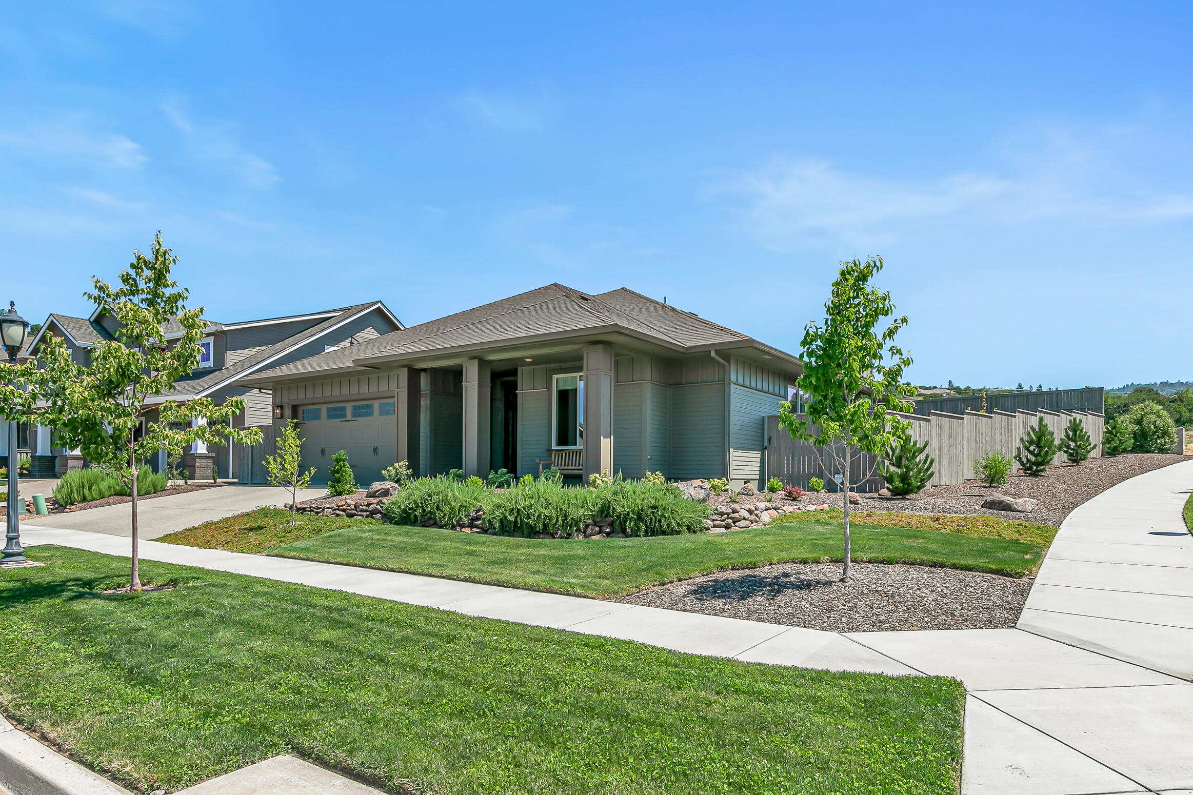 Practically new single-level home on a large corner lot in the desirable Summerfield neighborhood of East Medford! High ceilings, wide-plank engineered hardwood floors, living room with ceiling fan and renovated gas fireplace, dining area with sliding glass door to covered patio, kitchen with quartz dining island and counters, soft-close maple cabinets, tile backsplash, walk-in pantry, stainless five-burner gas cooktop, convection oven, built-in microwave, dishwasher, and refrigerator. Primary with ceiling fan, glass door to back patio, full ensuite bath with walk-in closet, tiled floor and shower surround, quartz double vanity, and water closet. Two guest bedrooms with closets and full bath with solar tube, quartz vanity, and tub shower with tiled surround. Laundry room with built-ins, utility sink, washer, and dryer. Two-car garage with pull-down ladder to attic storage. Fully-fenced private backyard with ornamental trees and sunny gardening areas. Inquire for details!