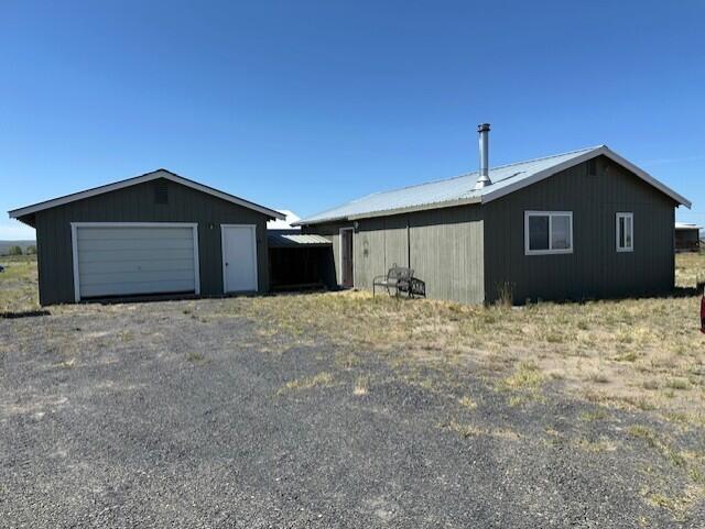 Move in ready - Charming 1-bedroom, 1-bath frame home on 1.03+/- acres with wood and electric heat. Enjoy the fenced back patio just off the kitchen—perfect for relaxing or entertaining. Paved road in front, detached garage with automatic door opener adds convenience. Property is fenced on both sides and adjoins the airstrip, offering direct access to your spacious 2,146 +/-sq ft airplane hangar. Ideal for aviation enthusiasts seeking a unique and functional setup.