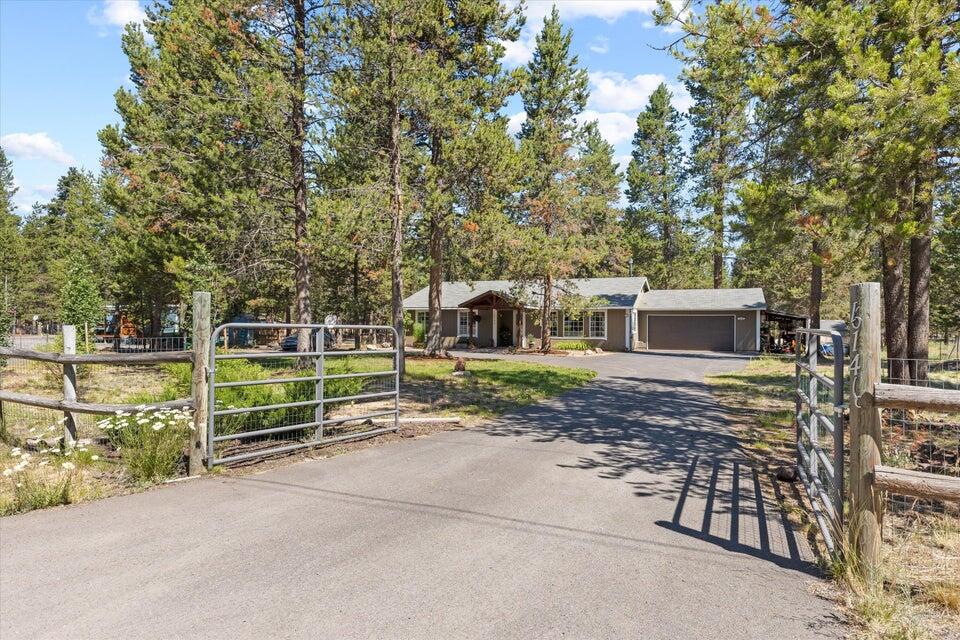 A charming single-level home on one acre with a NEW WELL, whole-home water filtration, and an open layout with a pellet stove, durable vinyl-plank floors, and a wood-beamed ceiling. New carpet in the bedrooms and fresh paint inside and out. It's truly move-in ready. A grand pergola paver-path entry, 2-car garage, circular paved driveway, fully-fenced acre, covered back porch, two paver patio areas, lush lawn shaded by mature trees, chicken coop, fenced garden area, extra space to park your RV, and a cozy fire pit under the stars. Shed and covered carport/storage, no HOA. On a cul-de-sac. The home has an attic fan system to keep the house cool. Opportunity to create a true Americana Homestead with horses, chickens, goats! All appliances included. Welcome home to a one-acre natural paradise in Central Oregon less than a mile from the Deschutes River and La Pine State Park. Bonus: receive a $1,200 lender credit toward your closing costs for a rate buydown - ask for more info!