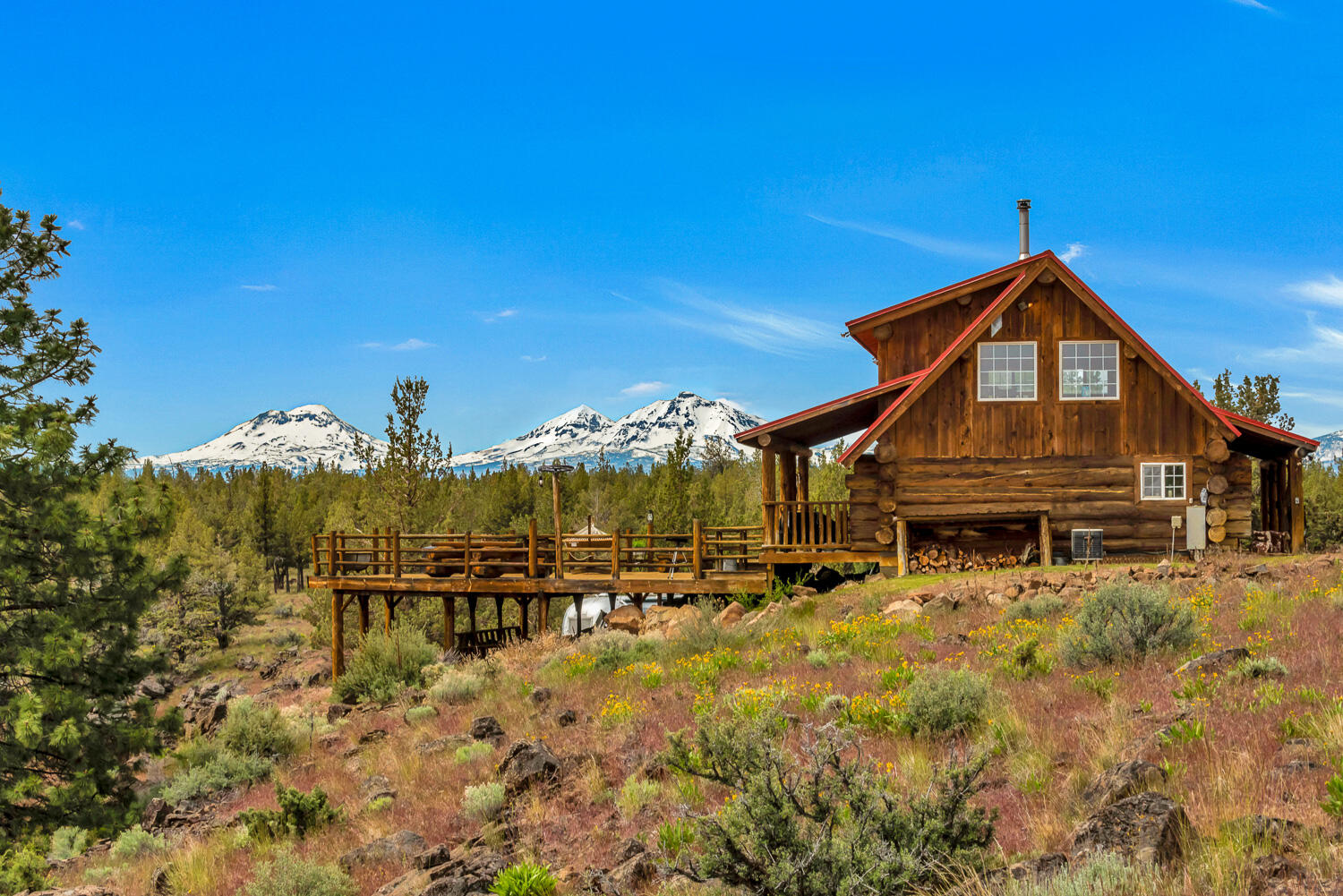 Secluded private getaway on peaceful 39.71 acre parcel w/incredible panoramic mountain & canyon views. Log gated entrance, hand scribed log cabin, 2 barns, log round pen, fenced & crossed fenced. Perfect setting at the end of a private paved road. Property is bordered by Deschutes Land Trust and BLM on two sides. 10 miles into the quaint town of Sisters. Refurbished 1965 Airstream guest quarters. Level, maintained property amongst junipers & pines. Enjoy incredible sunrises and sunsets from deck.