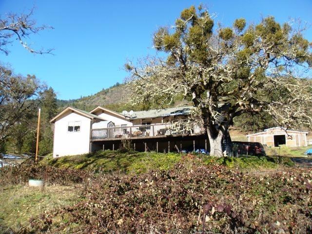 Bring your horses and farm animals to this great Applegate property and enjoy the Views, Views, Views! Solid home with open floor plan, vaulted ceilings, and beautiful wood burning rock fireplace. Large deck and room to entertain. Gorgeous views of the valley and surrounding mountains from every room. 8 stall barn plus additional area for animals and pasture. Usable, rolling land only 10 minutes to Ruch in the sunny Applegate.