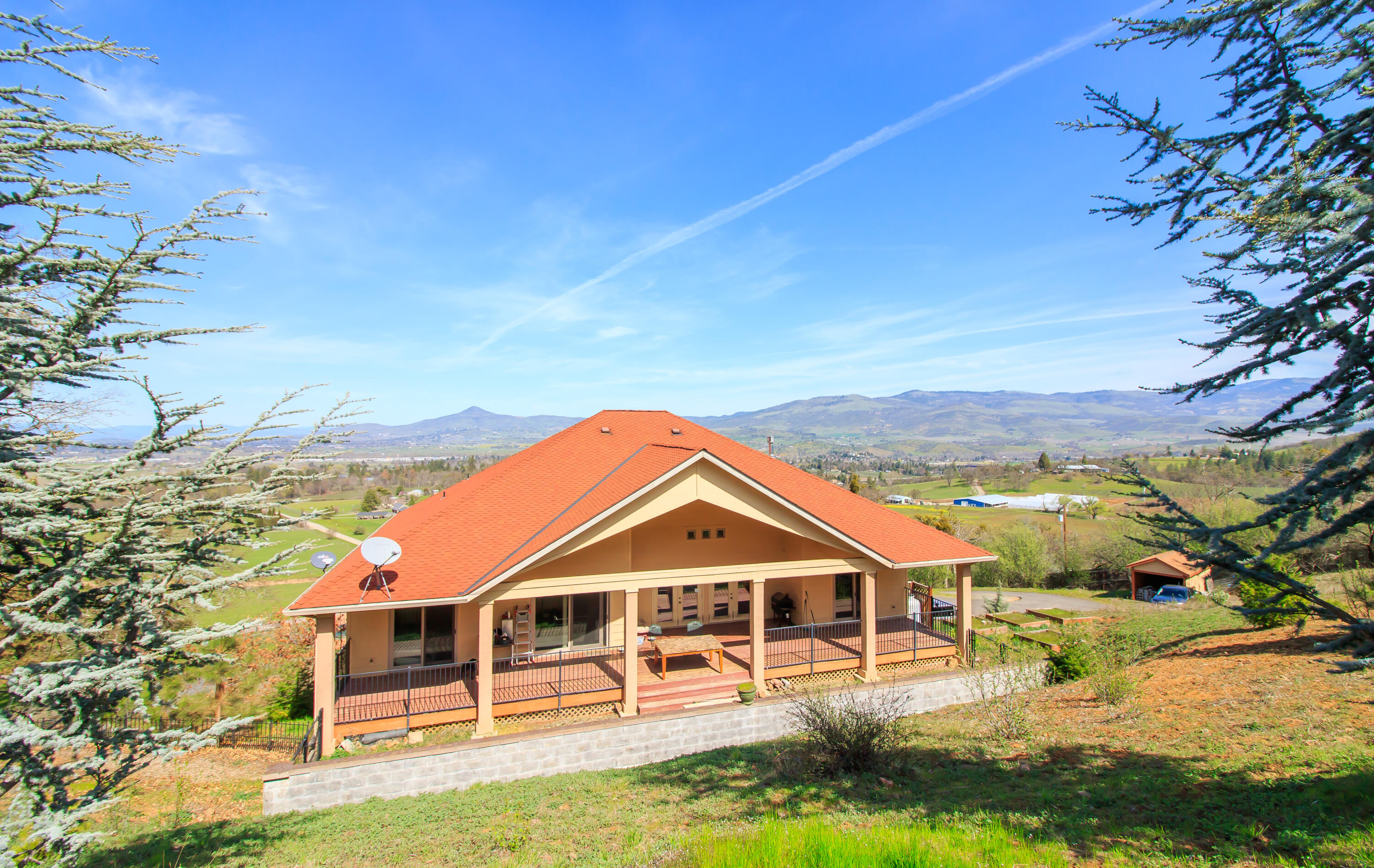 Million Dollar Views of the city lights, vineyards, and valley from this 2006 custom built Mediterranean home on top of the hill w/50year architect comp roof. Sunny sloped 2.76 acres w/TID irrigation rights! This 3 bed/ 3.5 bath home boasts 3284 sqft with two large rooms with in suite bathrooms, an open living area, soaring ceilings, office/den, huge kitchen w/ granite counters, maple cabinets, pantry, island as well as sitting bar. Main suite has a fireplace, two walk-in closets, large jetted tub, walk-in dual shower and tile floors w/ entry to the back deck. Great central location close to Jacksonville, Medford, & Ashland .The home is also close to several wine tasting rooms. Property is gated, fenced and has a flat area below the house with power access that a shop/ADU could be built, buyer to do their own Due Diligence. RV/ trailer parking. Oversized 2 + car garage, with room for shop space or extra storage. Finished basement w/polished/stained concrete floors.