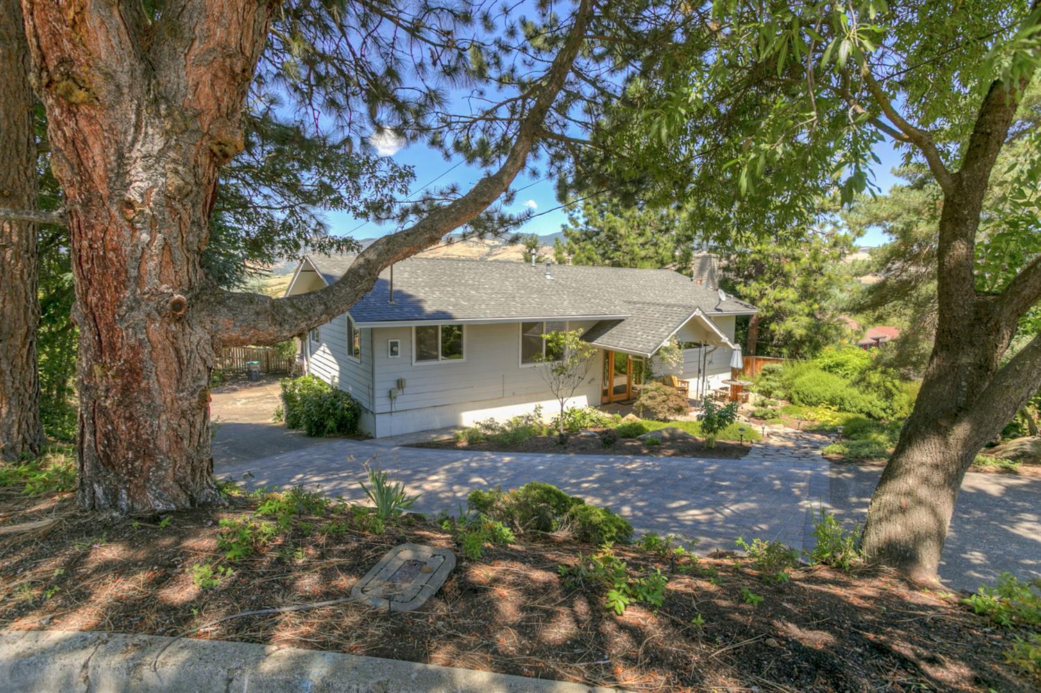 End of cul-de-sac privacy ensures peaceful living in this wonderful home that enjoys views of Grizzly Peak and adjacent park. Spend time on the back deck overlooking drought tolerant landscaping, fruit trees and lovely patio/hot tub area. Guests or in-laws will enjoy a private and bright daylight basement with its own full bath that opens directly to the garden. Natural light fills the main level that is perfect for entertaining. Master bedroom is also on the main and has sliding glass doors that take in the wonderful views. All of this yet still close to downtown Ashland.