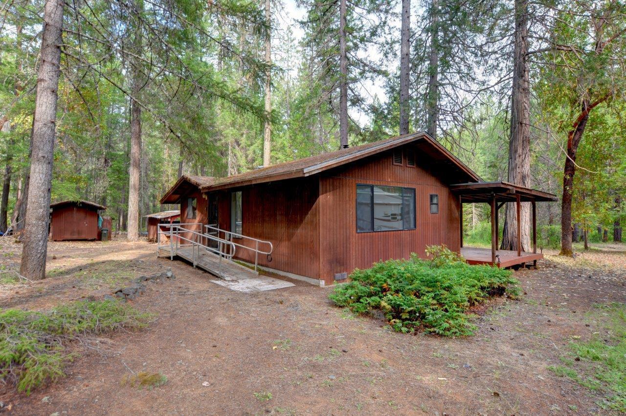 Discover cozy comfort in this 1 bed, 1 bath retreat location nestled on 5 acres has a lot of opportunities to make this retreat your own. Surrounded by nature and wildlife, this property offers a peaceful, private setting with a spacious covered porch, wood stove, and abundant natural light. The open layout includes a large bathroom with a tub, single vanity, and a separate mudroom with sink and laundry hookups. Outside, enjoy multiple sheds, a 12x16 shop, carport, RV parking, and hookups which is perfect for projects or guests. With a well, septic, and handicap accessibility, this home has great bones and is ready for your excitement! Don't miss the opportunity to make this humble abode in the woods your own personal retreat!