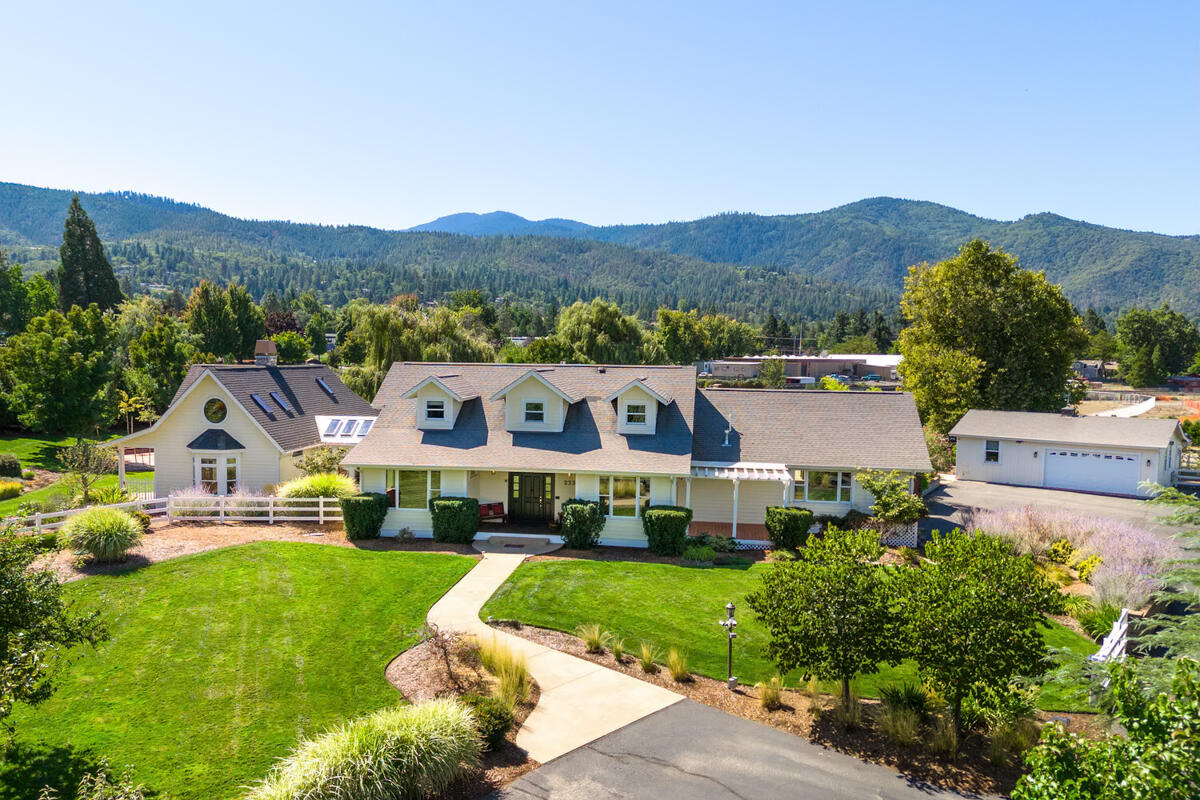 Resort-style living in beautiful Ashland, Oregon. Two lushly landscaped acres just outside city limits provide the perfect place for the family seeking a balanced life. The gracious Cape Codstyle house has abundant windows, wood and natural stone that give the interior a sunny and relaxed Pacific Northwest vibe. Artistic custom touches will surprise and delight: look for the mermaid! The primary bedroom wing will become your private retreat, with stone fireplace, loft and spa-like bathroom with gorgeous mosaic tilework. Outside, a spectacular pool with kitchen and stone fireplace invite family fun and informal entertaining. The home wellness
center has an exercise room, steam bath, sauna, and a light-filled studio. An in-ground trampoline, pickleball court and fully equipped media room add to the resort feel. Whether you're looking for a special home for an active family, a sanctuary to rejuvenate and relax or a showplace for entertaining, you'll find it here. Ask for feature list.