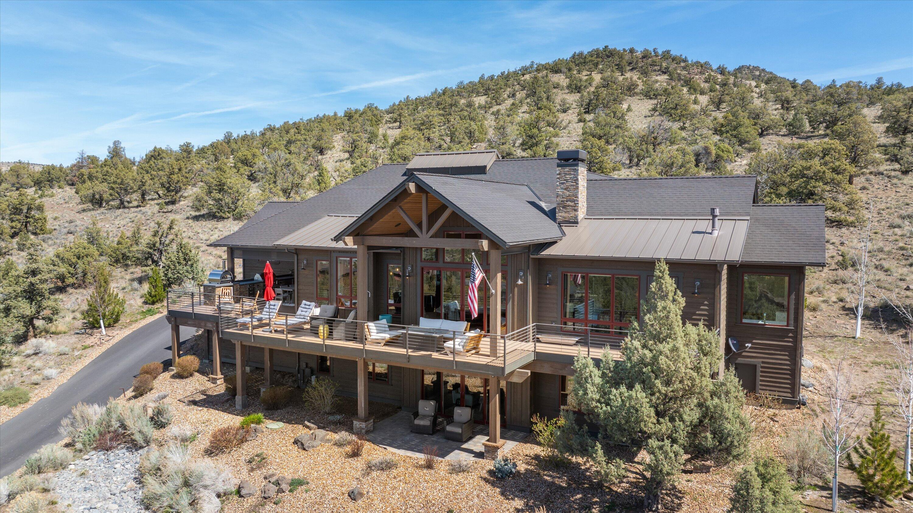 Take in panoramic Cascade Mountain views and the gorgeous sunsets famous at Brasada Ranch from the back deck that expands the length of this beautiful home. The deck features two gas fire pits, outdoor kitchen with pizza oven, and plenty of room for outdoor seating. As you enter the home you are greeted with warm sunlight through tall windows in the great room which lead to an open kitchen that provides ample space for entertaining with an island and butler's pantry. The main level includes Sonos surround with indoor/outdoor sound, an additional bedroom or office, spacious laundry room and the primary bedroom. The primary bedroom features a fireplace, two walk-in closets, soaking tub, heated floors, heated towel racks, and steam shower. Downstairs, you will find a bonus room, craft room, two en-suite guest bedrooms, with access to the outdoor covered patio. A large three car garage and views of the Powell Buttes from the front, complete this home.