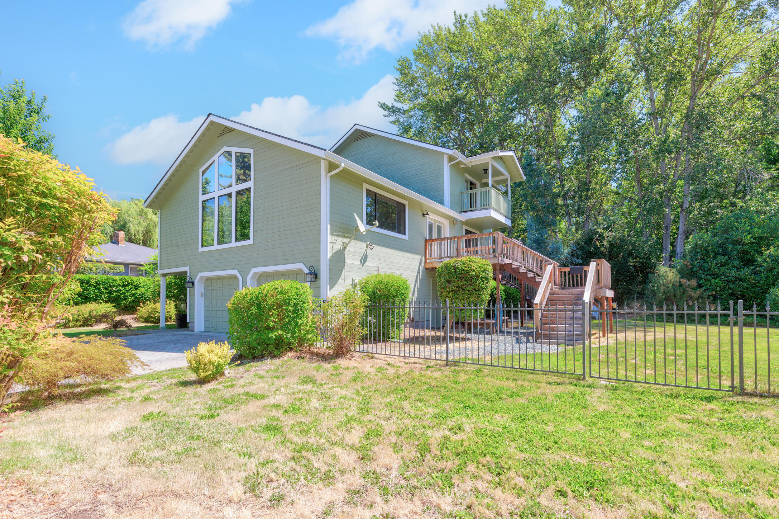 Here it is!  Desirable neighborhood! Ideal Southern Oregon living w/only minutes to the mighty Rogue River for fishing & fun! This fun 2,112sqft 3 bedroom 2 bathroom. Through the front door, stairs take you up to the loft style great room w/modern feel & bohemian touches. Beautiful Wood flooring throughout most of home. Kitchen has fantastic custom island giving you extra counter space for entertaining. Garden window, stainless appliance, granite counter, dining area, French doors out to back private deck. Living room area has vaulted ceiling, panel windows gathers in natural light! French doors bring you to side deck w/stairs to side yard. Two guest bedrooms & bathroom near stairs leads up to primary en-suite w/private covered deck. Two car garage is extra deep for parking 4 cars or work shop hobbies! laundry room has shoots from both bathrooms. Oh the yard! Rod iron fencing & gate gives a stately yet private feeling to a large & lush yard! This one you don't want to miss!