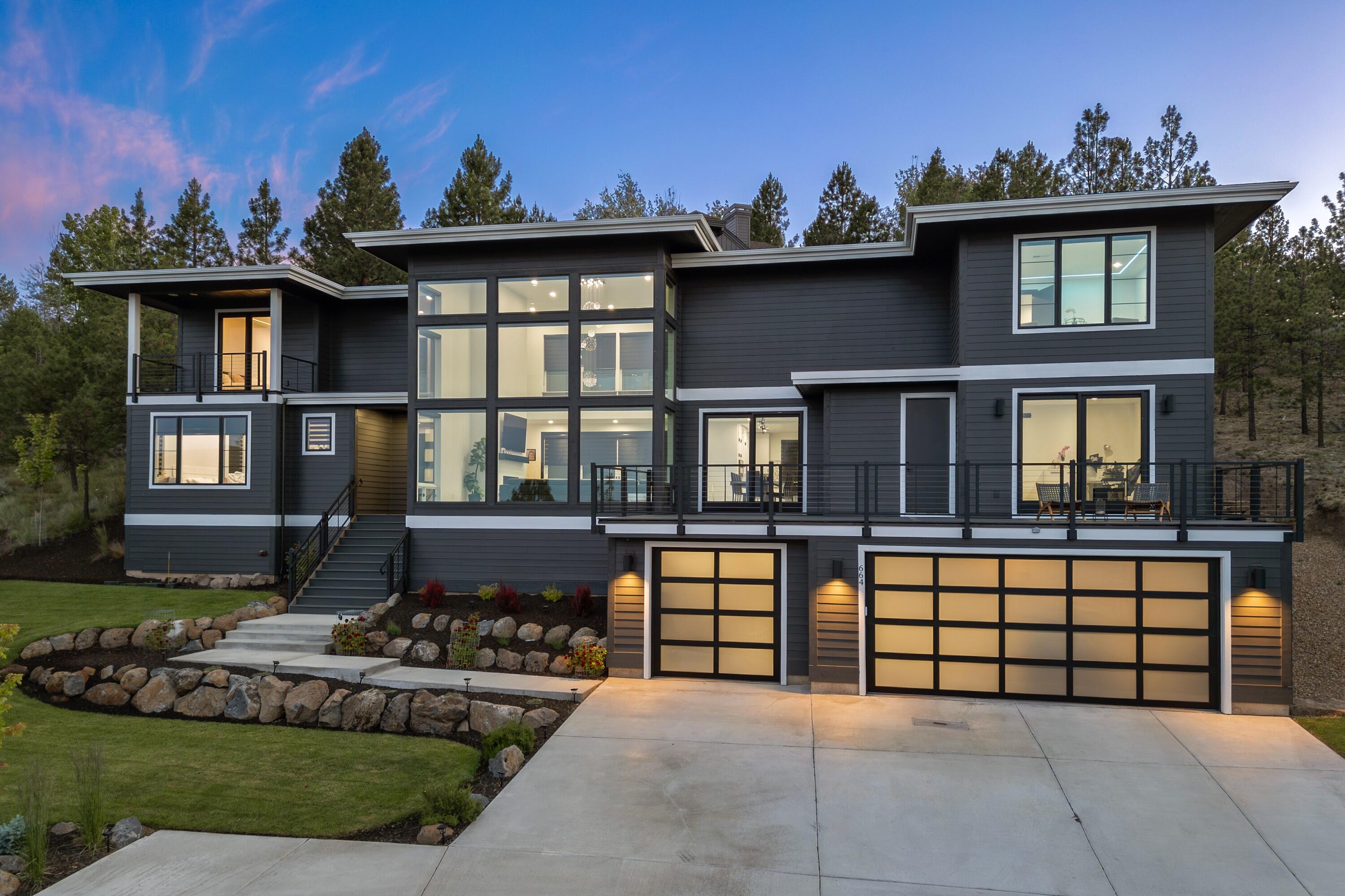 Experience elevated living on Awbrey Butte w/ this sleek & modern masterpiece. Designed w/ elegance in mind, this stunning home showcases imported Italian marble flooring & custom RGB LED ceiling lights throughout. The great room features soaring ceilings, fireplace, & floor-to-ceiling windows that frame the easterly views. The gourmet kitchen is a showstopper—featuring a large island w/ breakfast bar, granite countertops, double oven, walk-in pantry, & high-end Café commercial appliances. The main level offers a luxurious primary suite  w/heated bathroom floors, dual vanities, soaking tub, tile shower, & walk-in closet. Also on the main level: a private office & cozy den! Upstairs, enjoy a game room & dedicated home theater, 2 junior suites each w/ large walk-in closets & private balconies, plus an additional bed & bath. Enjoy 4th of July fireworks from the expansive front deck or entertain year-round on the covered back patio. Minutes to trails, parks, shops, and downtown Bend!