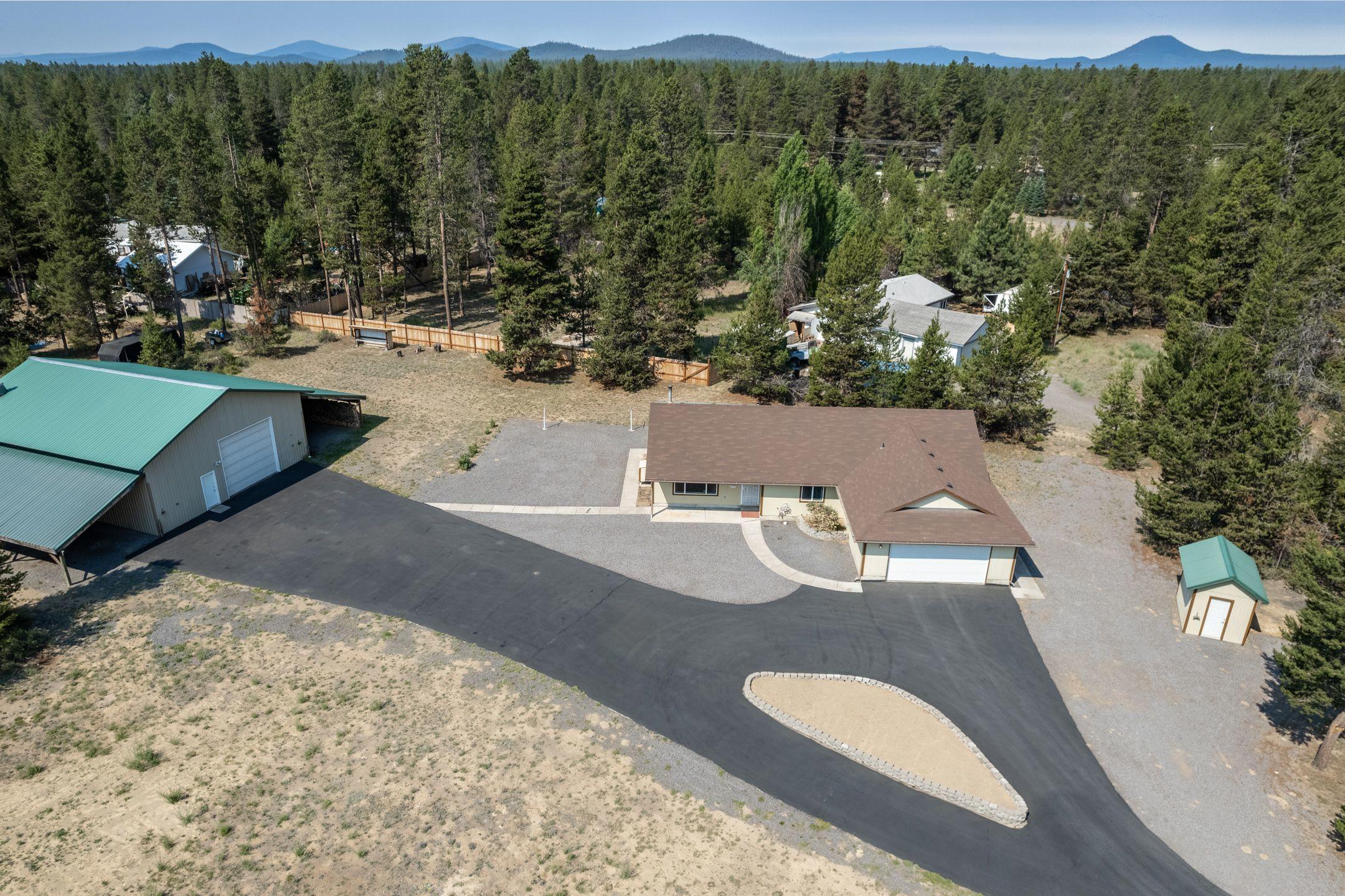 This neat and tidy, move in ready home has fresh interior paint, newly resealed asphalt in the expansive paved driveway, a NEW WELL, and an amazing 4000 square foot SHOP (including lean to's) on the property!  The house boasts a spacious and open great room, a large countertop peninsula in the kitchen, has a wood burning stove, 3 large bedrooms, and a utility room/mud room accessing the garage. House temperature is controlled by the heat pump and newer windows in addition to the wood heat. Outside, there is a covered back porch for winter wood storage. The insulated shop includes full bathroom, laundry hook up, and a loft area with a heated room that locks. This property definitely has something for everyone.