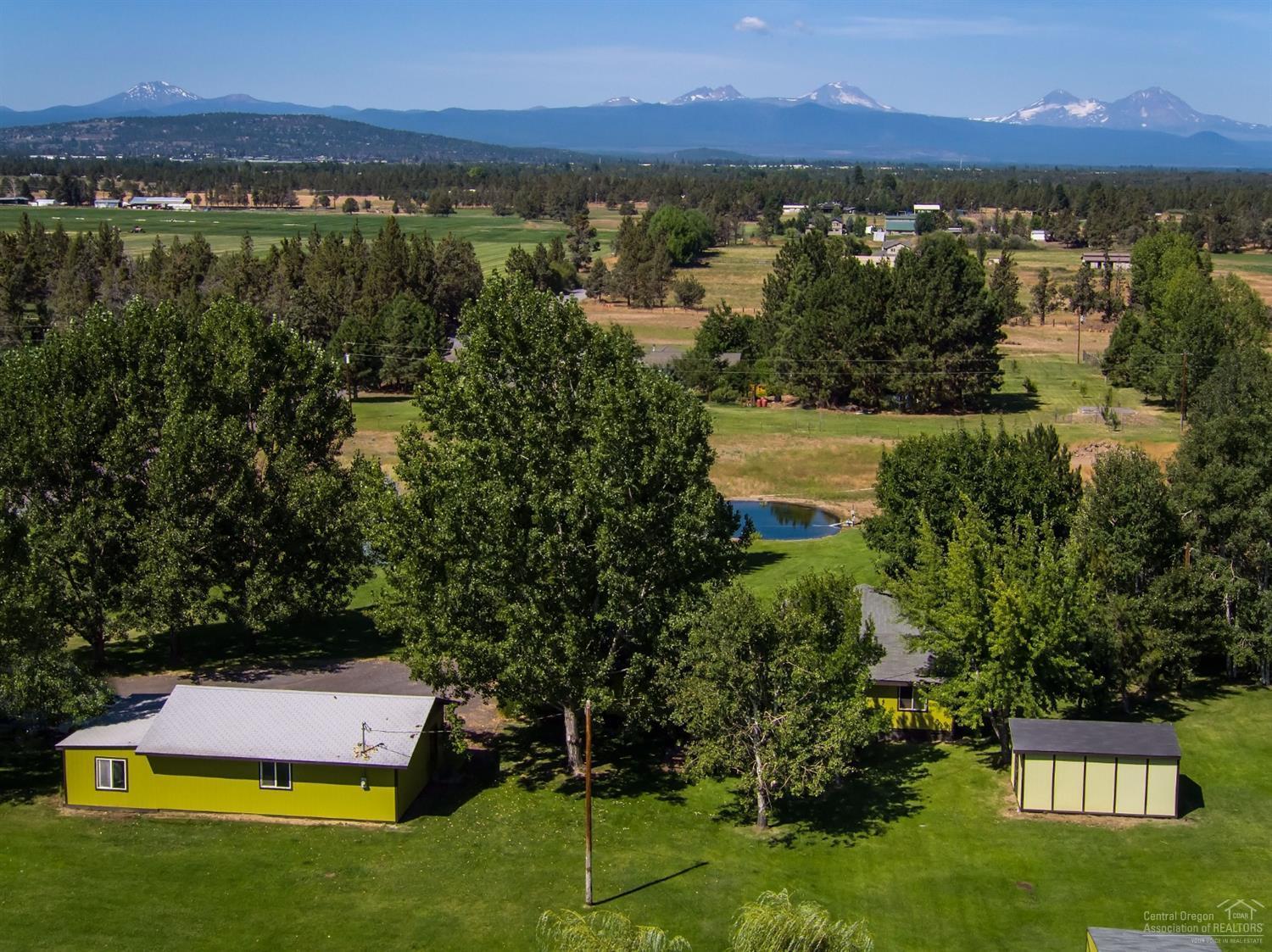 Who said you can't have it all! Irrigated small acreage (in-ground, automated sprinklers), park like setting, close to town (but so quiet), Cascade Mtn views, Avion water, large yr round pond, beautifully treed & gorgeous large windows in stick built addition to take it all in (all permitted). Horizon sunrise AND sunset. In last 6 years ALL NEW: ductless heat pump, exterior paint (some interior), luxury vinyl plank flooring everywhere except bedrooms, most appliances (SS), insulated bathtub, ductless heat pump, storage & bar with granite top, sliding doors, large living room windows, bathroom vanities, insulated grow room, lined pond & paver patio. Energy efficient with ductless heat pump & certified wood stove. Nice separation of master from other bedrooms. Master bath is complete with bidet. There are 2 great outbuildings with power, in addition to the lien to & detached garage with lg shop area (220 power). All in a wonderful neighborhood with good folks (& fun get togethers)