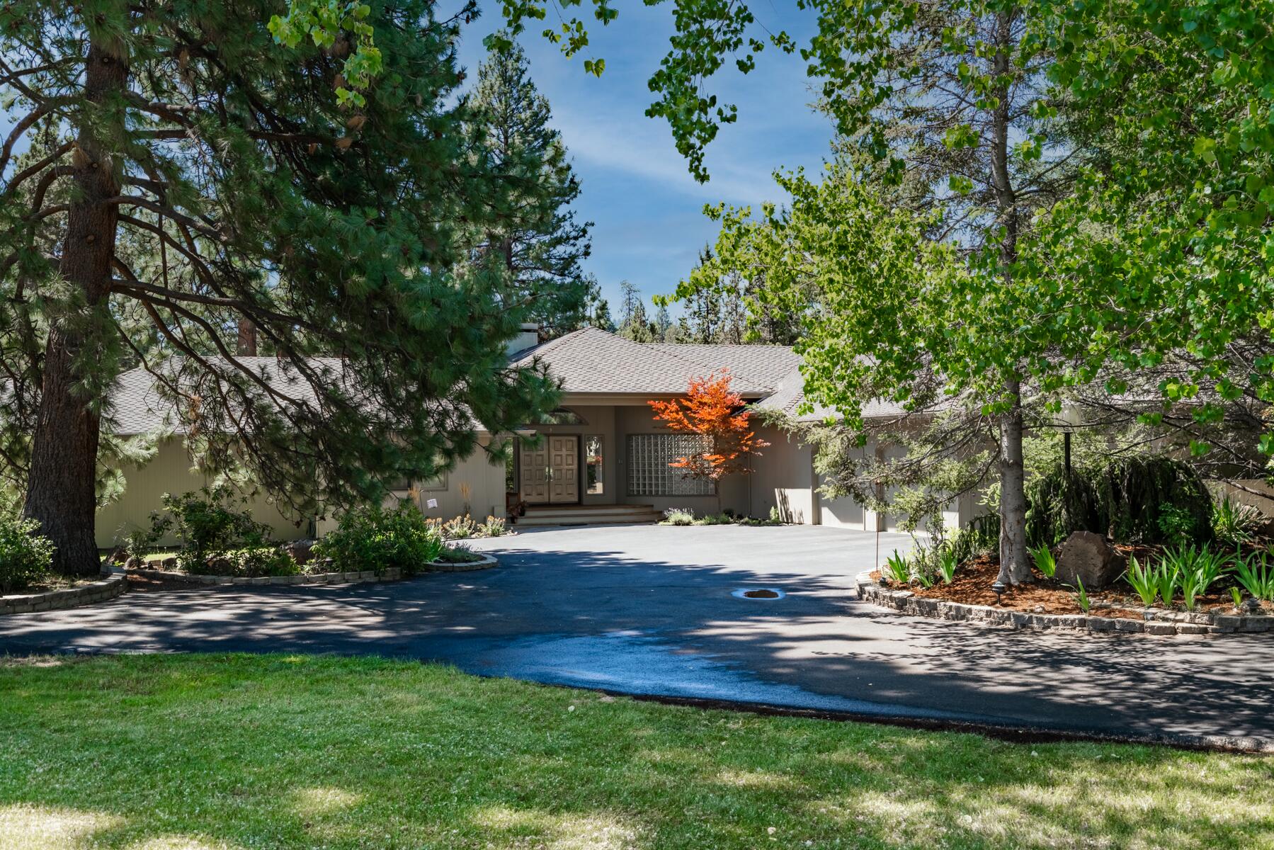 This home is located on 2.42 acres virtually in town as the eastern edge of the property is the city limits, but the property is in the county. The property is in northwest Bend on the Deschutes River canyon and has a deeded easement down to the river behind the house. The property has 2 acres of Swalley Irrigation and with a fully automatic system. Extensive decks overlook an expanse of grass and wildlife that pass through almost daily. Chaney Road is a privately owned, dead-end street, within walking distance to Riley Preserve. This property is on septic and has a shared well with two other neighbors. The home has a three-car garage.
The home is a contemporary 3,378 sq. ft., single level, 3 bedrooms, each with its own private bathroom, and 2 additional half-baths. The master bedroom has a fireplace and en suite bathroom.  The home has two furnaces and two heat pumps. The roof is a 50-year roof in good condition. There is a separate shed for mower and extra storage.