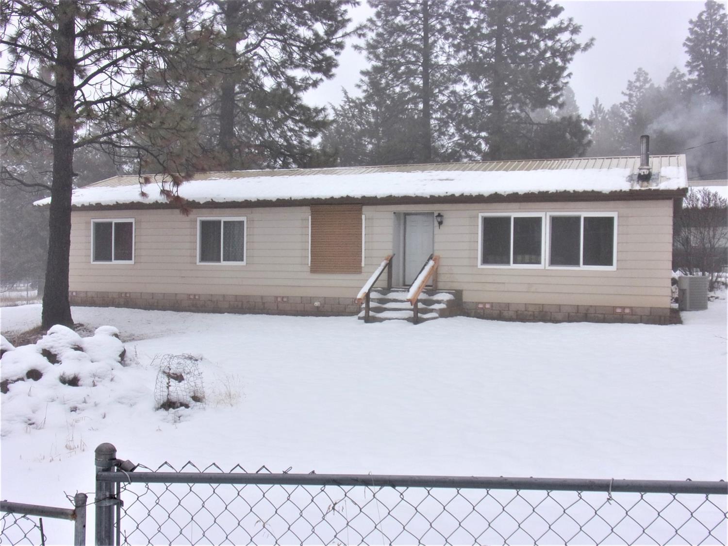 Beautifully remodeled manufactured home with spacious open floor plan, ramp, and wide doorways for ease of access. Tucked away on 2.68 acres it has a gated entry and multiple outbuildings including a large shop with two finished rooms and a third with water and sewer hookups. Loft in the shop for storage. Also includes a chicken coop and pole barn.