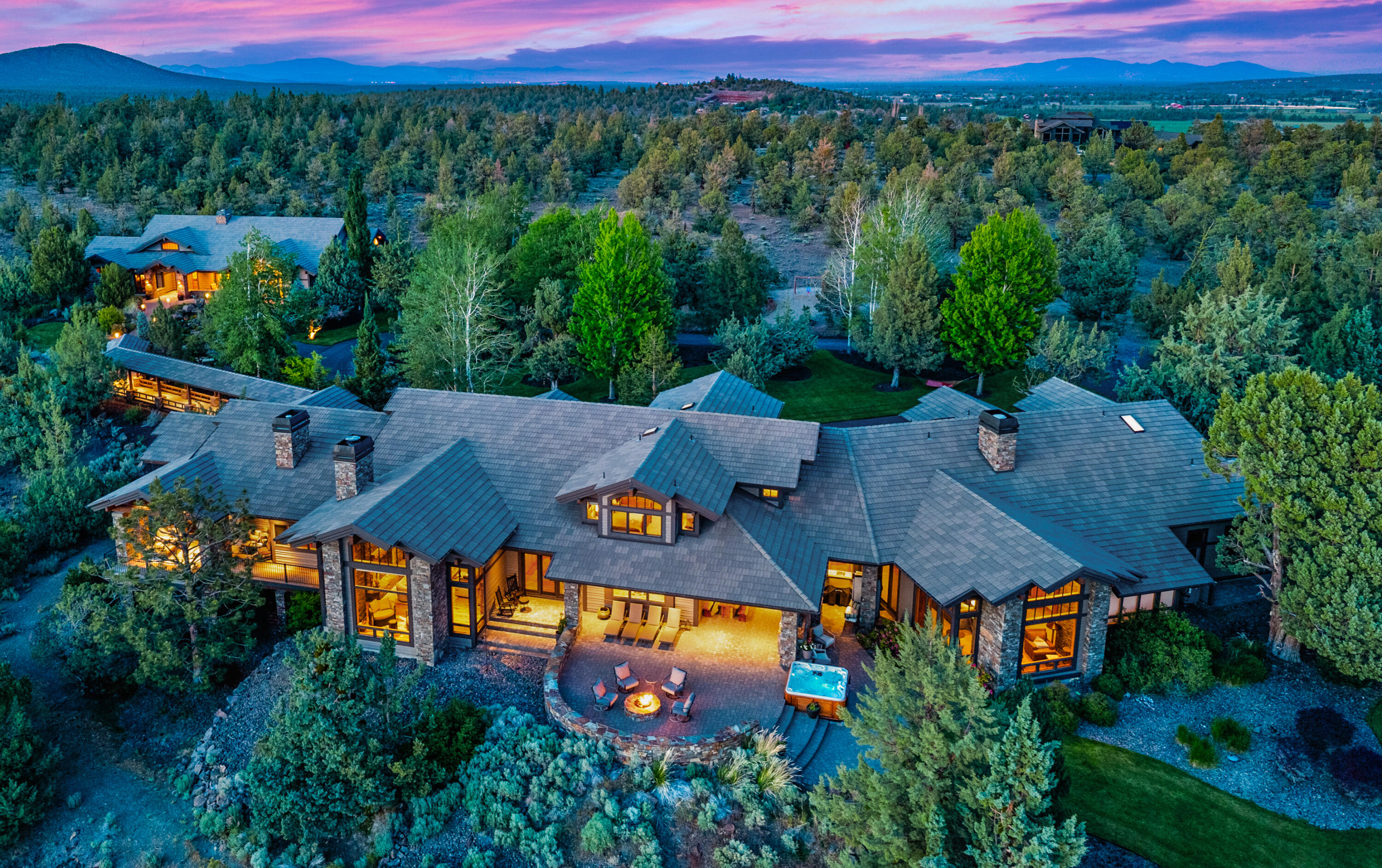 An architectural masterpiece in Bend's coveted Golden Triangle. Set on 9.77 private acres behind custom gates, this Northwest style estate by Norman Building & Design offers sweeping Cascade Mountain views. Walls of glass frame the high desert, anchored by a grand stone fireplace & massive beams. Chef's kitchen w/ slab granite & sculptural hood opens to dining & copper-topped wine bar. Steps lead down to a wine cellar & tasting room. Main-level primary suite w/new gas fireplace, spa bath & panoramic mountain views. Dramatic breezeway connects to a 2,095 SF guest house. Enclosed parking between both garages for 11 cars or 9+2 RVs. Expansive patios, fire pit, water feature & salt water hot tub under the stars. Well appointed main-level office with Mtn. views, exquisite wood finishes & timeless craftsmanship define this legacy estate—secluded yet minutes to downtown Bend. Only 25 min.  Redmond Airport, Near golf, Mt Bachelor, equestrian estates & world class recreation.
