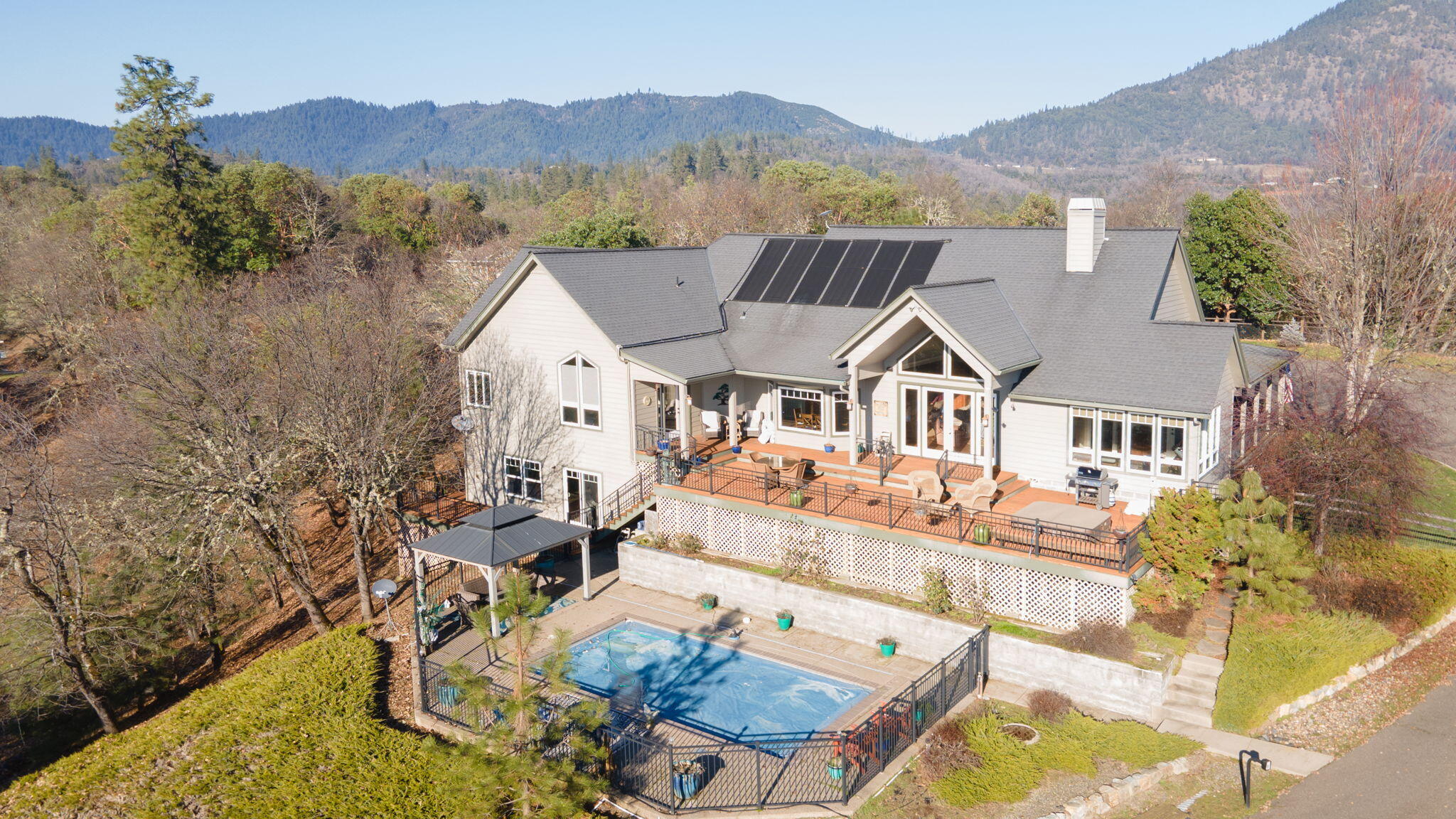 Breathtaking views! Nestled on 5.19 private acres, this 3,720 sqft retreat is the perfect blend of comfort, luxury, and endless possibilities. Imagine waking up to panoramic views, sipping your morning coffee on the deck, and spending warm afternoons lounging by the sparkling pool or soaking in the hot tub under the stars. This home offers a peaceful sanctuary for relaxation and a stunning backdrop for entertaining. With 3 bedrooms and 4 full bathrooms, there's space for everyone. The primary suite on the main floor provides convenience and privacy, while the additional guest or hobby room above the shop adds flexibility for your creative pursuits or hosting friends and family. The massive RV garage with its own bathroom is a dream come true for adventurers or hobbyists. Whether you're seeking a quiet escape, a place to create lasting memories, or a space to host loved ones, this property delivers on every level. Your dream life begins here—don't miss the chance to call this home!