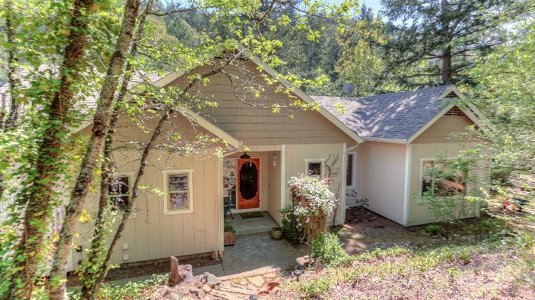 Own your own waterfall directly in front of your house on 7.11 acres of totally secluded park like setting! This custom home is located just two blocks outside the Ashland city limits. The home offers 2600 square feet and 4 bedrooms and 2.5 baths plus den with lots of amenities that include, handcrafted Klamath River rock fireplace, timber frame construction living room, 9' vaulted beamed ceilings, hardwood floors, open floor plan, master suite on the main level and antique vintage interior doors. Recent upgrades include the heat/air system, thermostat, most of the interior and exterior paint, refinished hardwood floors, and more. You will love the creek, waterfall and sitting area near the creek. This is one of the most unique and beautiful properties in southern Oregon that should not be missed.