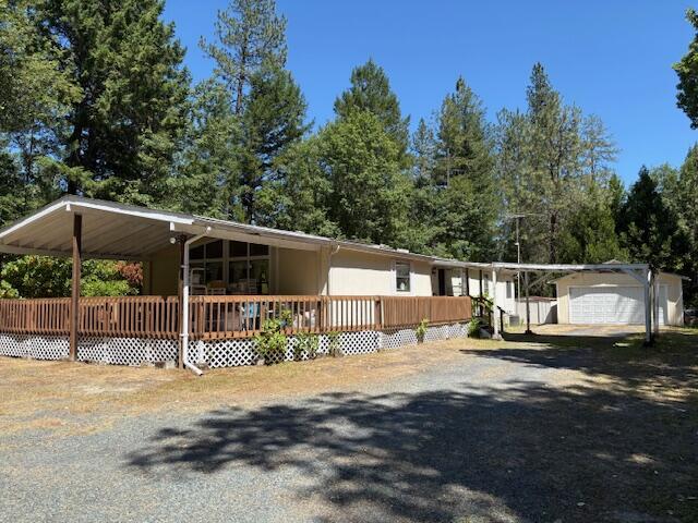 Privacy, yet close to town. This beautiful 5 acre parcel is just minutes from downtown and offers wooded privacy in a pristine peaceful setting. The manufactured home has an open floorplan, large primary bedroom, a bonus room and over 1800 sq ft. There is a detached 2 car garage, a separate detached workshop and a large 30X40 shop built in 2002 that is big enough to store an RV. There is a lot to like about this property.