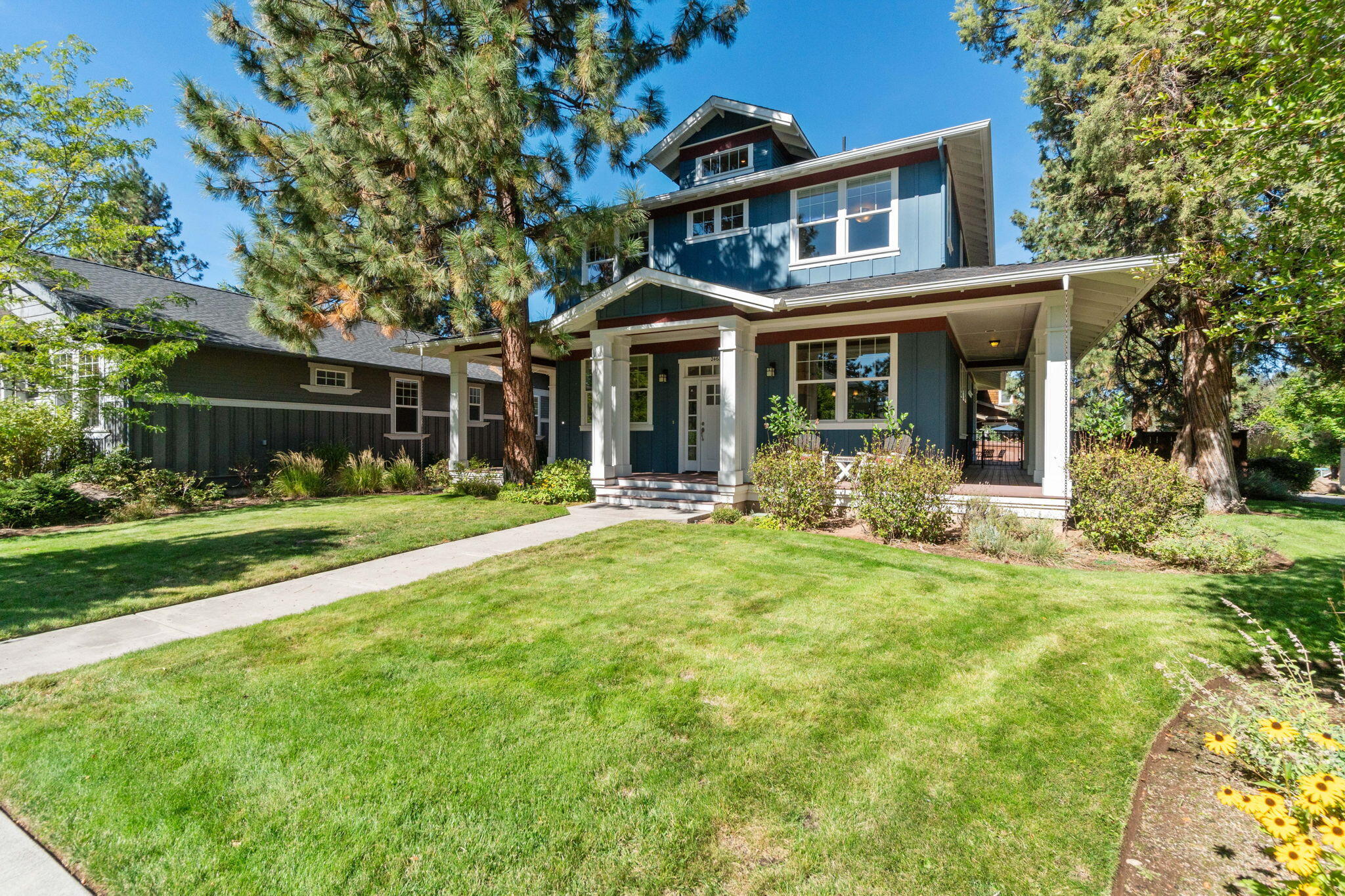 This beautifully crafted home by Gary Laursen boasts a large wrap-around porch facing south, with abundant windows that fill the space with natural light. The stunning entryway features coffered, wood-inlaid ceilings above elegant stone and hardwood floors. Double glass doors lead to an office, currently used as a TV room, with a striking coffered, lighted ceiling. The main living area is open and airy, with a gas fireplace framed in stone tile. The well-appointed kitchen offers ample storage, solid wood cabinetry, and an efficient pantry. The oversized primary bedroom includes a spacious, shelf-lined walk-in closet, with a luxurious en suite featuring a tile-surround corner soaking tub and glass-enclosed shower. Two more large bedrooms and a full bath complete the second level. The fully fenced backyard offers relaxation on the covered deck or paver patio. An oversized, attached two-car garage provides plenty of room for vehicles and storage, making this home a perfect retreat.