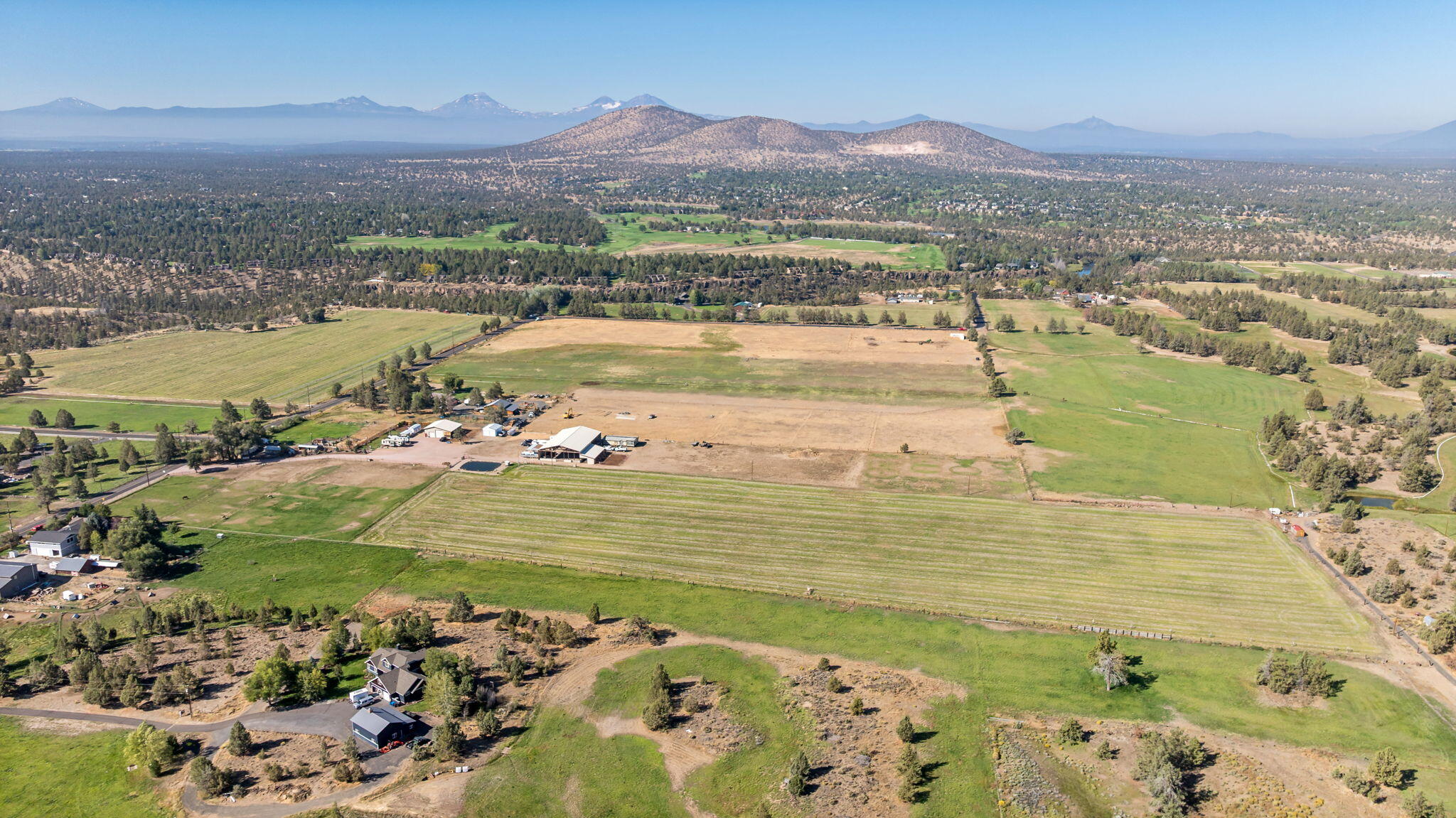 Experience 20 prime Central Oregon acres near the Deschutes River and Cline Falls State Park. With irrigation rights and panoramic mountain views, this property sets the stage for your dream home. Meticulously maintained, it's fully outfitted for horses and livestock, featuring fencing and cross-fencing throughout, along with thirteen acres of hay production. Equestrians will appreciate the impressive 8,400 SF covered riding arena, complete with 5 stalls. The grounds also include hay storage, a 48' x 48' pole-building shop equipped with water and 220 power, and a lean-to offering four additional stalls. Practical amenities abound—RV parking and storage, a well with a recently updated pump house, and a pond upgraded with all new equipment. Every detail has been thoughtfully taken care of, making this the perfect canvas for building the home you've envisioned.