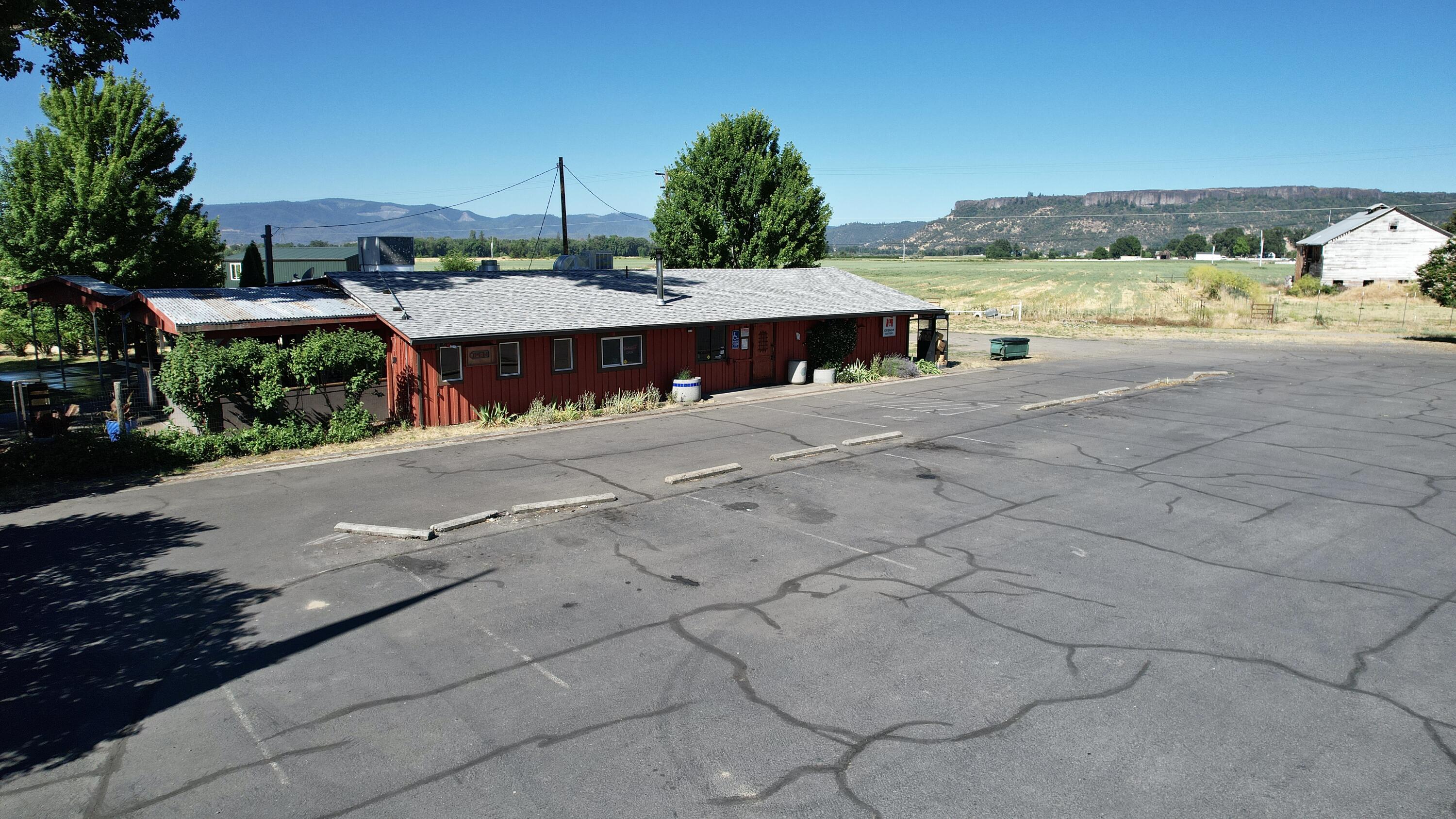 The Touvelle Lodge is a popular tavern with a dedicated local customer base, ideally located on 1.91 acres zoned RS (County-Rural Service Commercial) and enjoying a daily traffic count of 7,800 cars. This turn-key 2,140 sq. ft. bar includes a covered patio, band stage, and offers both indoor and outdoor seating with an outdoor bar and patio area. Recent renovations with new flooring, upgraded bathrooms, and a new roof, the property ensures modern comfort and durability. Patrons can enjoy live music during summer months, and the site features an RV pad with water and power hookups, an 800-sq. ft. shop with a 14-foot door and 20-foot ceiling on a concrete slab, a well with a 2000-gallon holding tank, and ample blacktop parking. The property is securely fenced, making it a versatile and appealing opportunity for investors or entrepreneurs searching to tap into an established business with significant growth potential. Owner will carry.