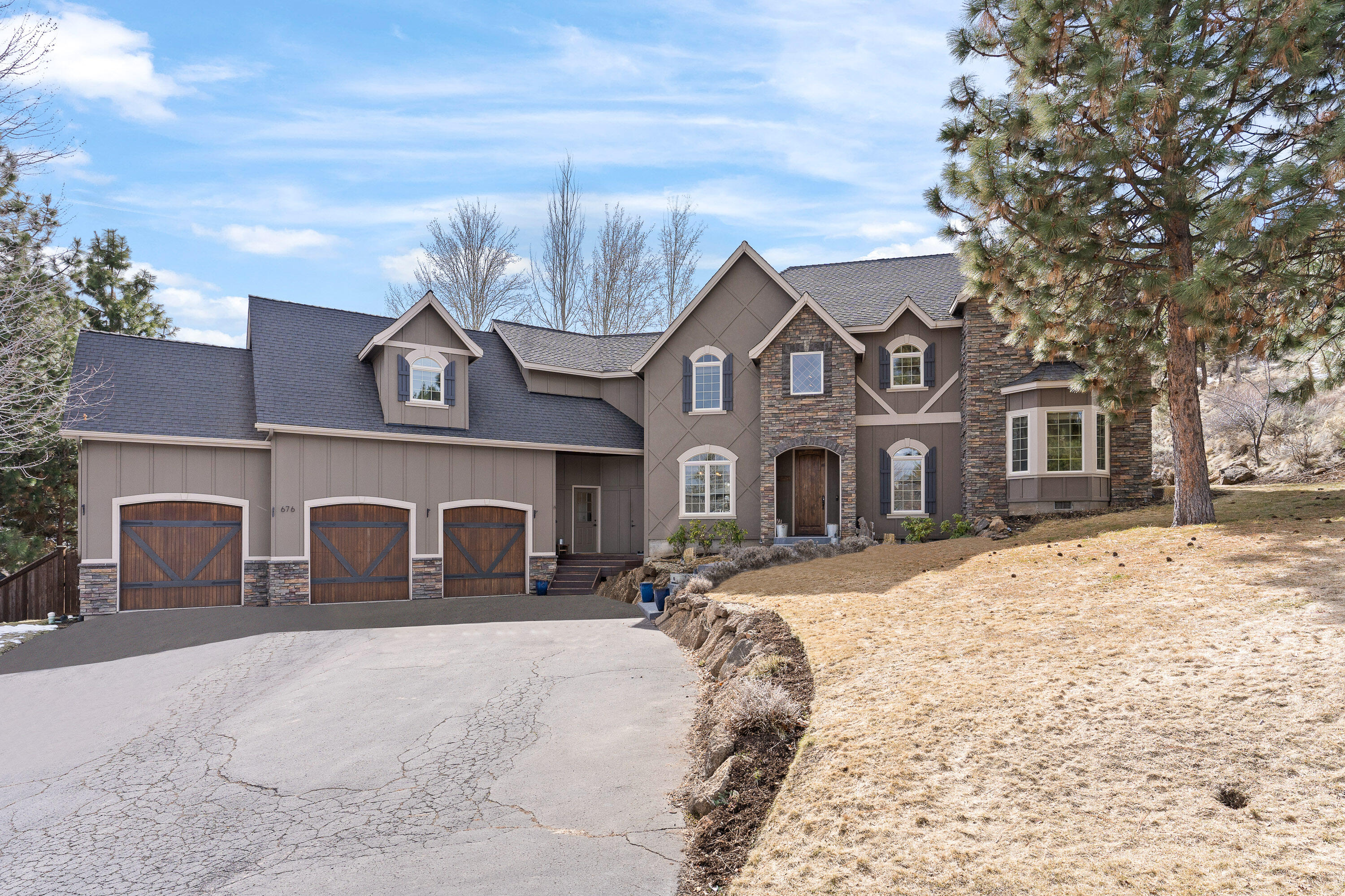 Discover luxury living on Awbrey Butte in this custom built home featuring a great room open floor plan, gourmet chef's kitchen, two dining areas and a large fenced backyard with privacy on a quiet street. The main floor includes an office and the primary suite that features a fireplace and sitting area. With 18-foot vaulted ceilings and southeast facing floor-to-ceiling windows, this home welcomes an abundance of sunlight and transforms into a gorgeous winter wonderland. Upstairs, you'll find three guest bedrooms including a junior suite, cozy loft, and a separate bonus room, offering ample space for everyone. Step outside to the backyard that features a rock outcropping, and raised garden beds. Enjoy your morning coffee in the private park-like setting, where wildlife wander freely. A large triple-car garage and easy access to downtown, First Street Rapids, and the Newport Corridor blend luxury with convenience. Welcome to the extraordinary lifestyle of Awbrey Butte living!