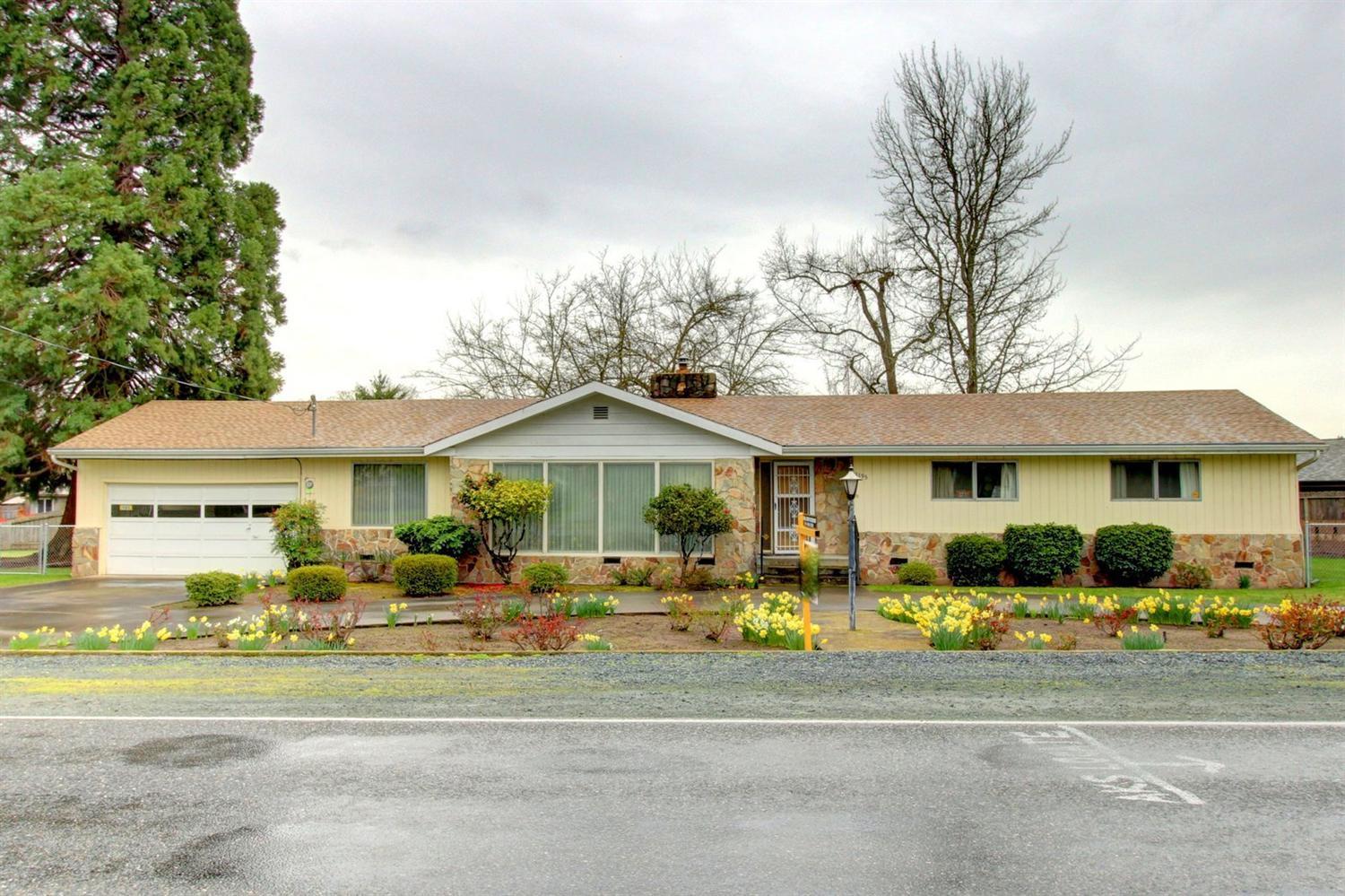 Live in your own personal park setting. This solidly built home has character and a unique design that allows for entertaining and also quiet and cozy spaces. There is a large master suite with walk in closet and step down sun room that looks out onto the lovely landscaped back yard. The family room has a raised hearth fireplace, a slide to the outdoor patio, and access to the sun room. From the attached 2 car garage, you can walk through to your own spacious, well-lit, air-conditioned work shop with storage. The back yard is completely fences with beautiful mature trees, irrigation with a well-built garden shed, and garden area. The roof is just over 2 years old. This home is in a perfect location to access shopping, medical care, parks and all that Grants Pass has to offer. Offered at $275,000. Home Warranty included.