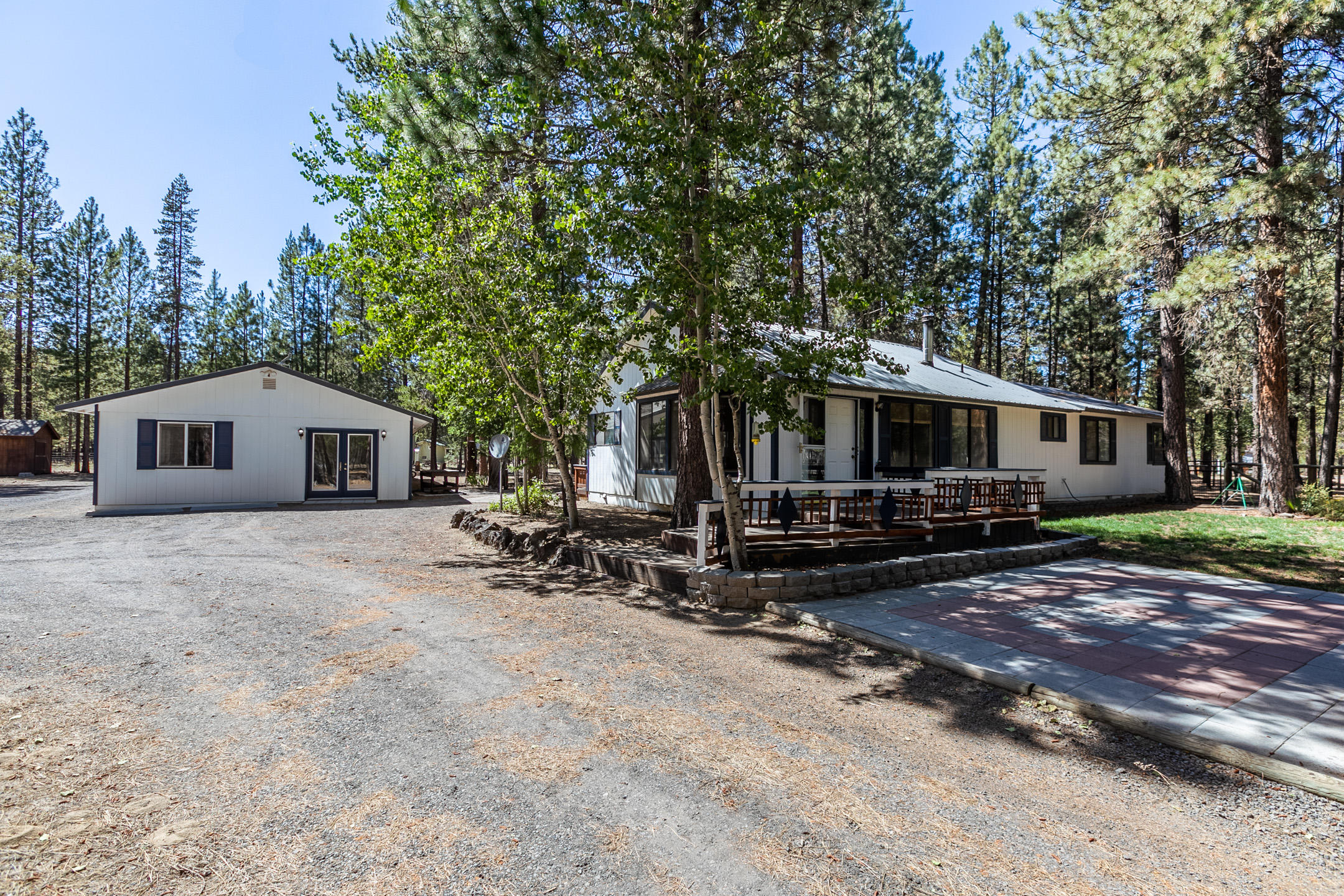 Nice home with open floor plan located in sought-after Ponderosa Pines on 1.37 wooded acres. Certified wood stove in living room, laminate floors, walk in closet with additional closet in Master Bedroom. Master bath has a soaking tub and shower. Detached family/game room with pool table (included in sale). Attached carport and workshop. 10 x 20 shed for storage or additional workshop. Fenced yard, great for pets. Front and rear patios and decks. Room to build a shop or additional garage. Close to mountains, lakes and rivers with the convenience of all that La Pine has to offer. Community water is $345 per year.