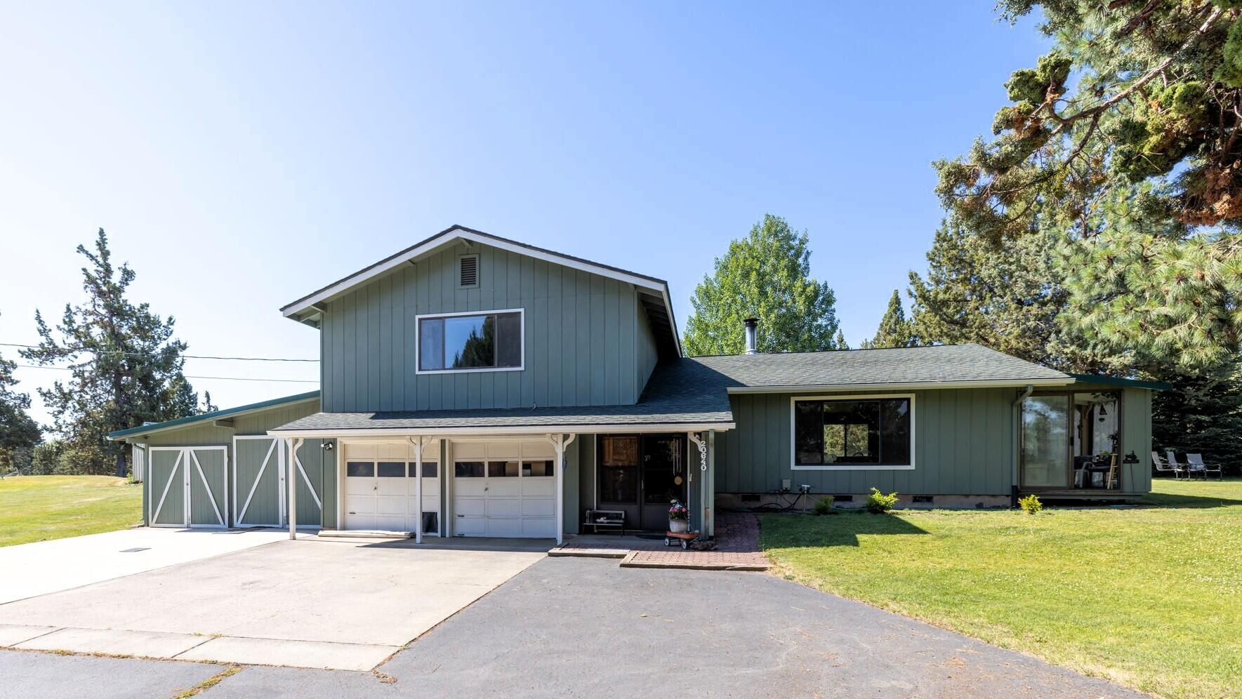 Discover the potential of this rare small acreage with irrigation in beautiful Bend. Privately located at the end of a quiet cul-de-sac, this 3 bed, 2 bath, 1,899 sq ft home sits on 2.48 acres with 1 acre of irrigation. Fully fenced and gated, the property features an attached 2-car garage and two large shops—a 45x65 shop with 14-ft roll-up door and a 24x36 shop with two bays and workshop. Rolling grassy hills, extra storage buildings, and plenty of room for hobbies, animals, or work. Inside, mini splits provide year-round comfort. In 2023, the home received electrical upgrades and 20 professionally installed solar panels, w/ direct Southern and Eastern exposure for excellent solar efficiency & storage, especially during our Central Oregon winters. Owned and loved by one family for over 40 years, it's ready for your updates and vision. Close to town yet private—perfect for a mini farm, retreat, or dream property. So much potential—just needs you. More Details: youtu.be/ZKuwFbvgmis
