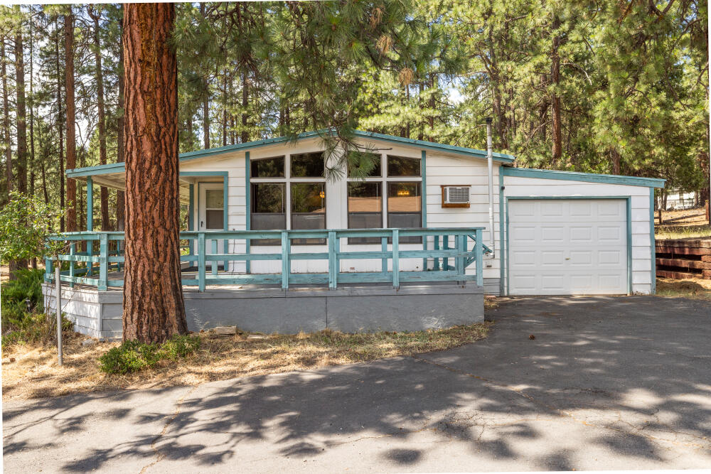 Accepting Backup Offers. This spacious 1979 mobile home sits on a peaceful 1.49-acre lot, tucked back off the road for added privacy. Offering 2 bedrooms, each with its own ensuite bathroom & walk-in closet. Inside, you'll find two living rooms, a dining area & a laundry room for everyday convenience. The open-concept kitchen features granite countertops, updated flooring & connects seamlessly to the main living spaces. A bonus flex room and versatile options for hobbies, home office or storage. Enjoy the separate work area  off the attached garage which also offers 1 garage space. The generous property also holds a separate shop with additional workspace+ possible lvg space, 2nd garage bay—perfect for projects, storage  or extra vehicles plus an additional barn, RV parking & paved driveways/parking areas for easy access year-round. Call for tour today!