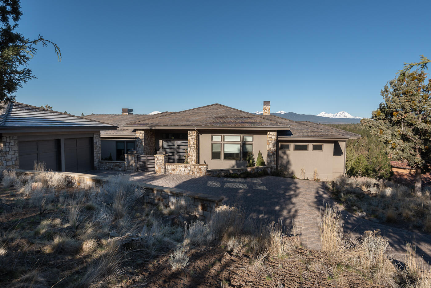 Stunning views from Mt. Bachelor to Mt. Hood. This exquisite modern style single level home has an open floor plan with large windows that capture the breath-taking mt. views. The living area features a beautiful low-profile fireplace with a large granite slab that complements the surrounding stone & floating shelves.  The master chef kitchen has top-of-the-line Miele appliances, solid granite waterfall edge island, custom built cabinets with all the newest storage design features you could ever dream of.  Just off the kitchen is the dining area with large sliding glass doors that enter out onto a large paver patio.  The main bedroom suite includes stunning views, gas fireplace, large walk-in shower, 2 vanities, soaking tub featuring a full wall of Carrara marble & mother of pearl. There is a large media room, additional 2 bedrooms with walk-in closets & full bath. Behind the oversized 2-car garage there is an art studio with sliding glass door leading to a private patio.