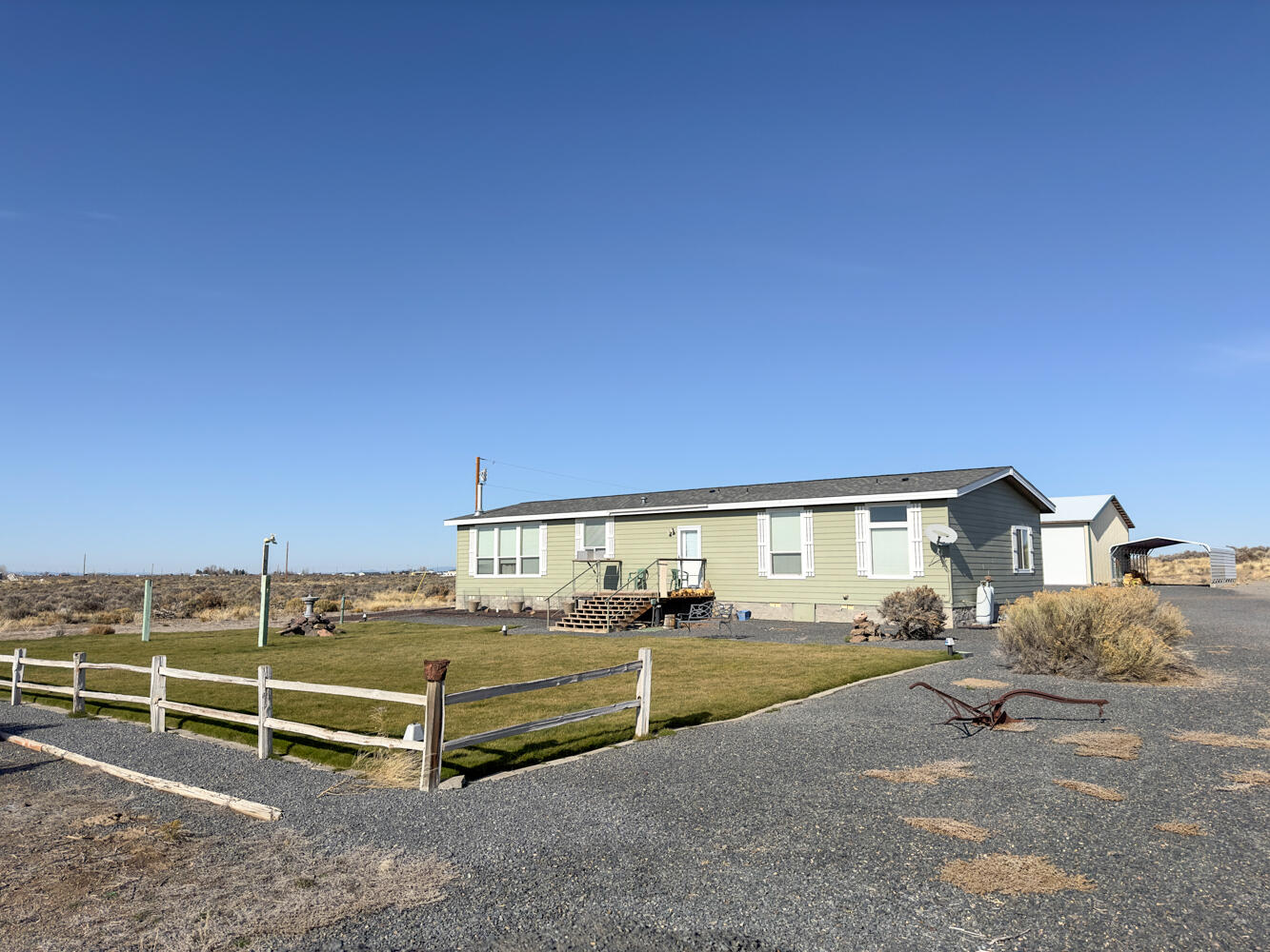 Welcome to Your Dream Home on 2.34 Acres! Discover comfort and functionality in this charming 2-bed, 2-bath residence w/ a versatile office space that transforms into a third bedroom. The open layout, ceiling fans, & a cozy wood stove create an inviting atmosphere. The large master suite features a walk-in closet and a jetted tub.  Fully equipped with appliances, including a washer/dryer, this home offers convenience. Outside, a well-maintained lawn w/ automated sprinkler, an inviting front porch, and a sunny back deck enhance relaxation & entertainment.  For outdoor enthusiasts, the property provides full RV dump & power hook-ups (110V, 30 amp, 50-amp connections). An impressive 2400 sq ft Shop/Garage w/ loft storage, cement flooring, & a 600 sq ft insulated ''man cave'' w/ two lock-out rooms completes the package.  More than a home, it's a lifestyle—embrace tranquility on the expansive lot, enjoy RV convenience, & savor luxury in well-appointed living spaces. Your dream home awaits!