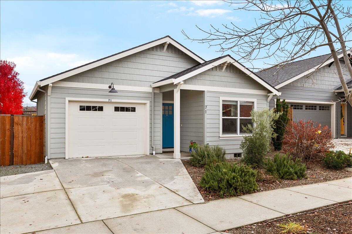 Inviting two bed, two bath, single level home built in 2019 by Suncrest Homes. Featuring vaulted ceilings, wood floors, walk-in showers and closets, and stunning natural light. The open kitchen includes solid surface counters, a kitchen island with bar seating and an array of windows letting in nice natural light. Primary suite includes a spacious bathroom with tile shower, dual sinks and walk-in closet. This Earth Advantage certified home provides energy efficient living to allow for lower utility costs. Enjoy the open, tastefully modern space, low-maintenance landscaping, custom planter boxes, a single-car garage, and much more. Short distance to downtown Talent, the dog park and public transportation.