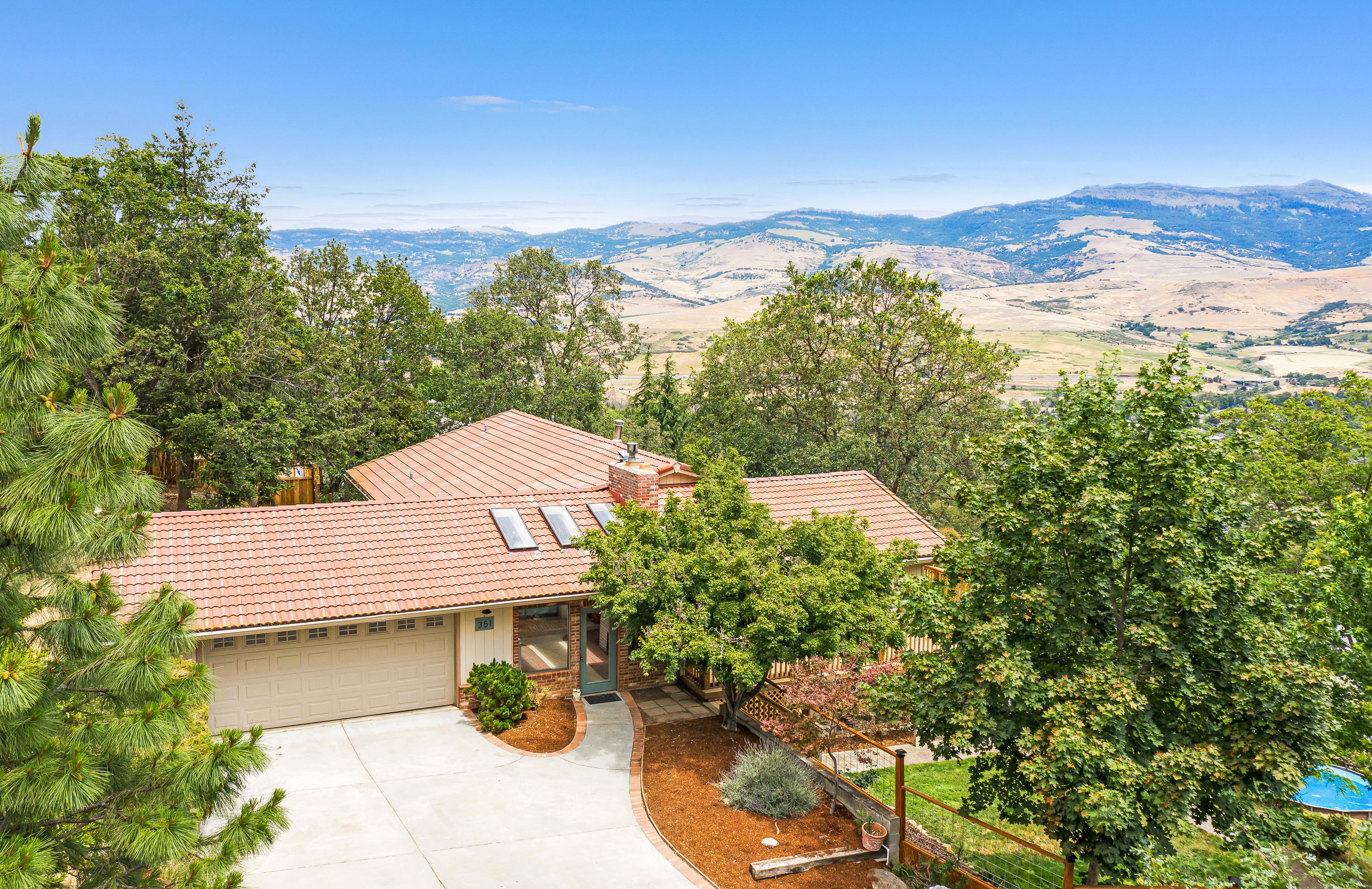 Versatile and spacious view home sited on an oversized 0.84 acre lot above Asante Ashland Community Hospital. Main level features three bedrooms and two full bathrooms including a master suite with dual vanity and walk-in closet, access to a recently rebuilt ~600 SqFt deck with incredible views of Grizzly Peak, walls of windows in a remodeled open-concept great room, renovated kitchen, stainless electric appliances, and pantry, along with a charming enclosed front porch, and two car garage. The lower level has three additional bedrooms, full bathroom, family room wood burning stove, separate exterior access, laundry, and storage area/mechanical room. Additional recent improvements include new laminate and tile flooring, bathroom vanity, quartzite counters, and all new light fixtures. Fully fenced and terraced grounds with TID irrigation rights, mature landscaping, fruit trees, and sunny gardening areas!