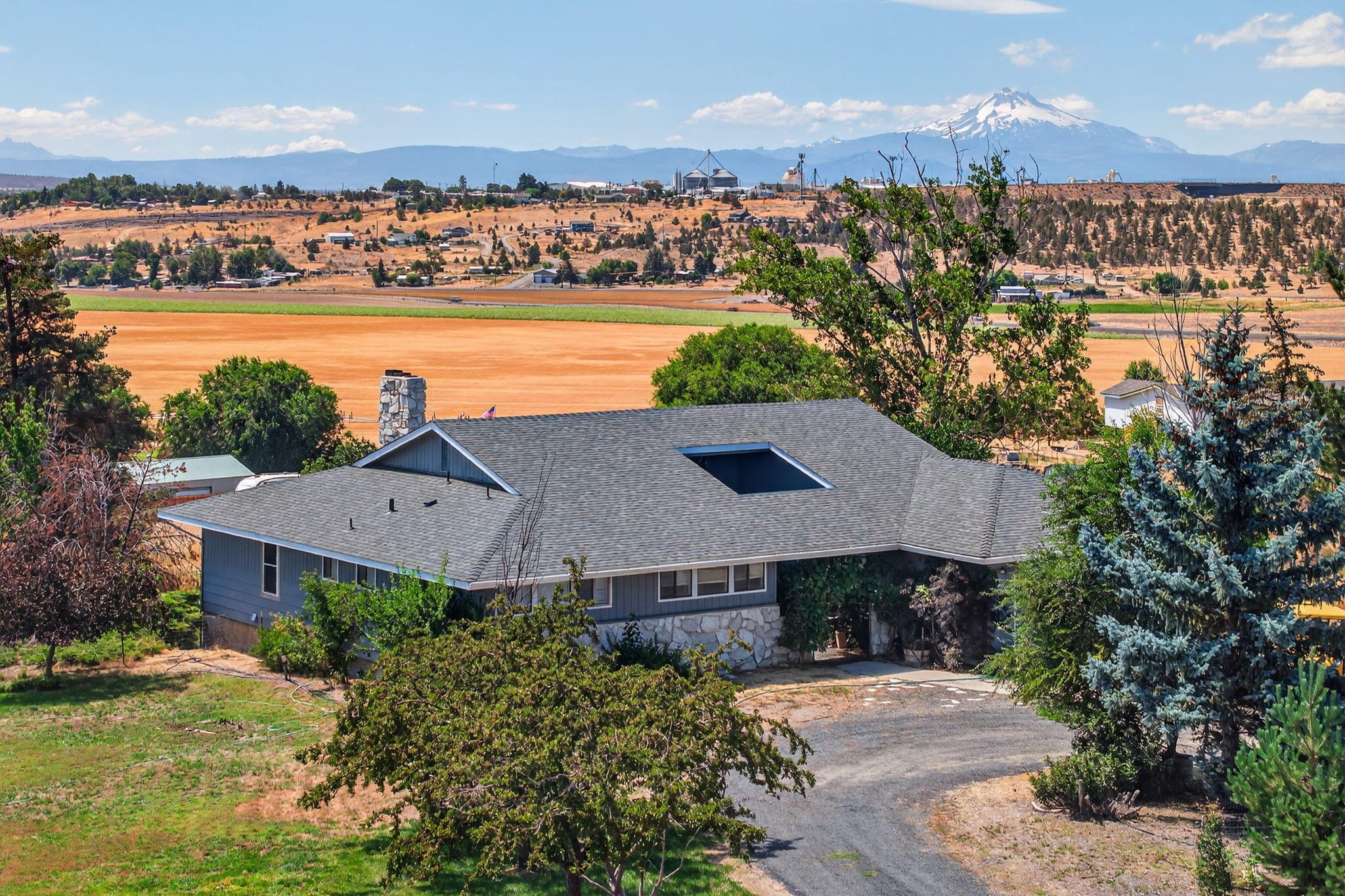 Stunning 5-bed, 3.5-bath retreat on 5 private acres with panoramic Cascade mountain views. Nearly 4,000 sq ft, split between two levels and with full kitchens on each floor, dual fireplaces, wide hallways, spacious rooms, and abundant storage. This is truly a unique house for those looking for some extra living space. Enjoy 4.6 acres of water rights, fenced yard/pasture, 30x30 pole barn, and attached 2-car garage. Recent updates include a newer roof (2019), hot water heater, 2 pressure tanks, septic system (2022), and fencing. Step out on the upper deck to enjoy views of cascade mountain peaks. Explore this peaceful setting with room to roam—perfect for country living, raising animals, hobbies, or simply enjoying the wide-open space.