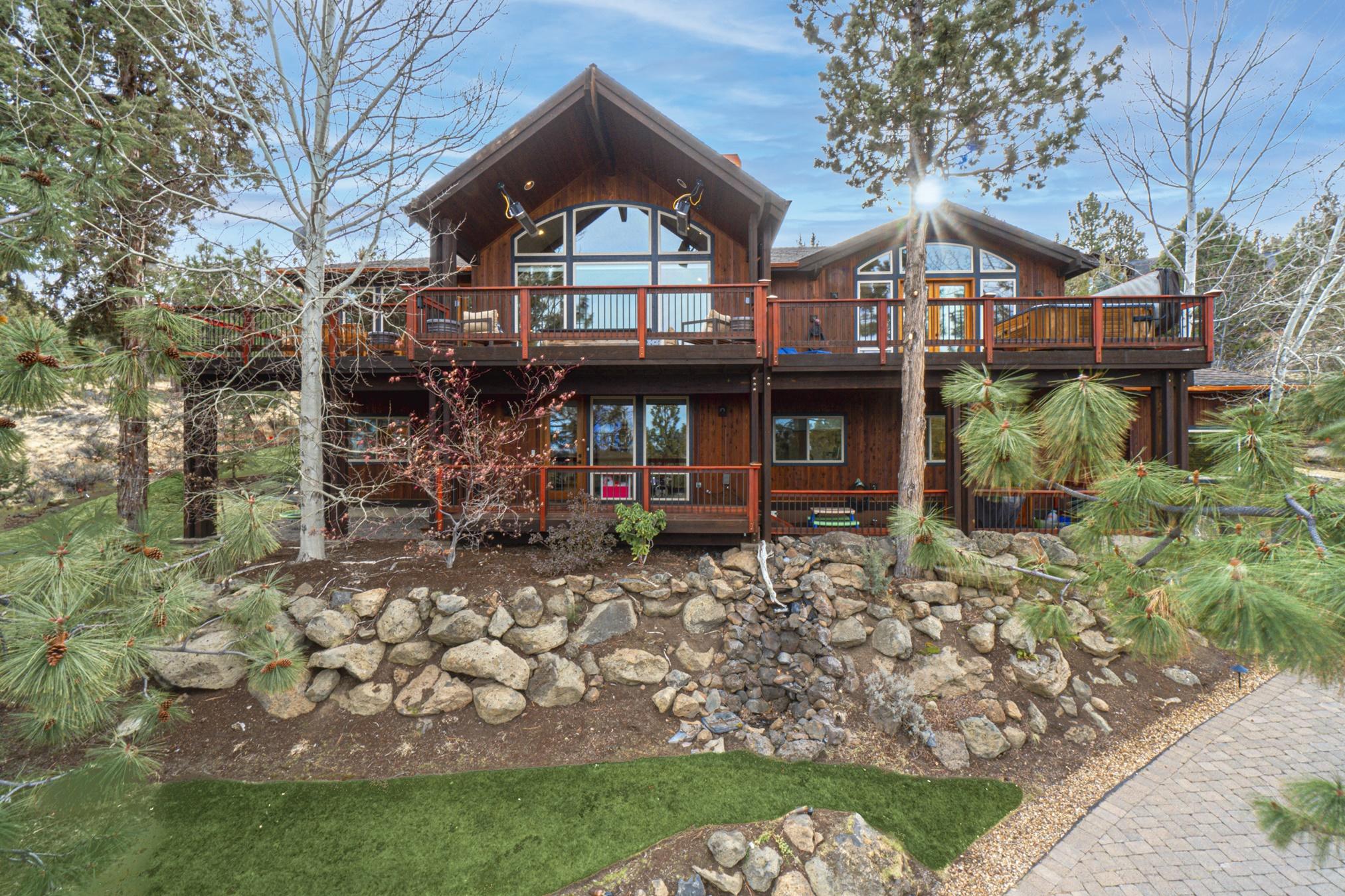 This gorgeous Awbrey Butte property offers stunning views of the Cascade Mountain range throughout this 3,881 sq ft home. With high ceilings and elegant wood beams, this spectacular home is full of natural light. The main floor features an open floor plan with a spacious living area and rock fireplace, an amazing kitchen, granite countertops, a large island, breakfast bar, pantry, and dining area with glass doors leading to the partially covered upper deck. The master bedroom is bright and airy with a luxurious master bath. The downstairs offers a comfortable living area with wet bar, wine/storage cellar, a bonus office space, three bedrooms, three full bathrooms, laundry, and an oversized 3 car garage. With beautiful landscaping, a heated driveway, and astounding views, this exquisite property is a must-see!