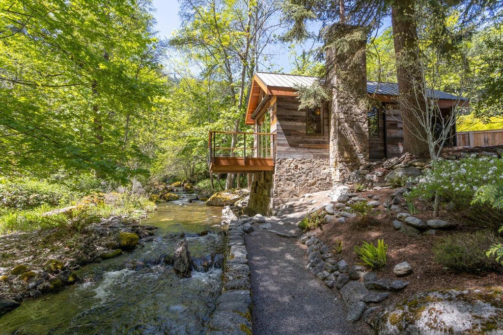 Adjacent to almost 300' of Ashland Creek, this property is arguably the most breathtaking piece of real estate Ashland has to offer. Bordered on 3 sides by Lithia Park, the privacy and exclusivity is like no other. The lush .87 acre property is fully landscaped with rock walls, crushed gravel walking paths, perennial flower beds, mature trees, and fabulous moss covered boulders. There are two cottages on the property. The newly constructed 396 square foot Millhouse features a deck that overlooks Lithia creek. There is also a 220 square foot studio/office space. The property is ready for your dream home and the Sellers are happy to share their designs for an architecturally pleasing home. Truly a once in a lifetime opportunity.