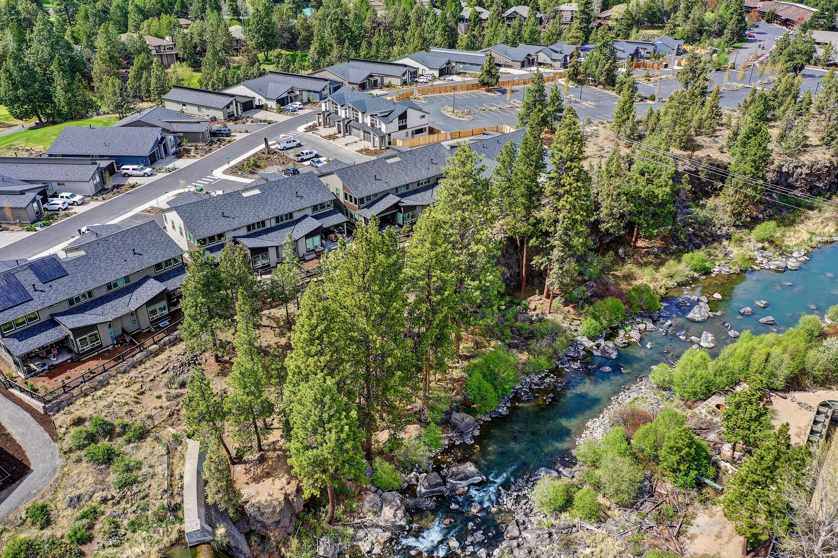 This distinguished townhome on the Deschutes River in NW Bend offers views and soothing sounds of the falls. The well-designed plan includes a 2-story vaulted great room with riverfront patio access, primary suite and office with custom built-in cabinetry on the main level and a second suite, additional spacious bedroom and bathroom, and loft w/wet bar upstairs. The kitchen boasts quartz countertops, under cabinet lighting, soft close drawers and cabinet doors, and high-end stainless appliances. The main-level primary suite has river view and riverfront patio access and spa-like bath with freestanding soaking tub, tiled shower, and custom California Closets system. The 2-car garage with epoxy floor accommodates a large truck and the extra-long driveway and guest spots in front ensure ample parking while entertaining. The Pointe is located 2 miles from downtown and includes private river access and front yard landscaping and townhome exterior maintenance covered by the HOA.