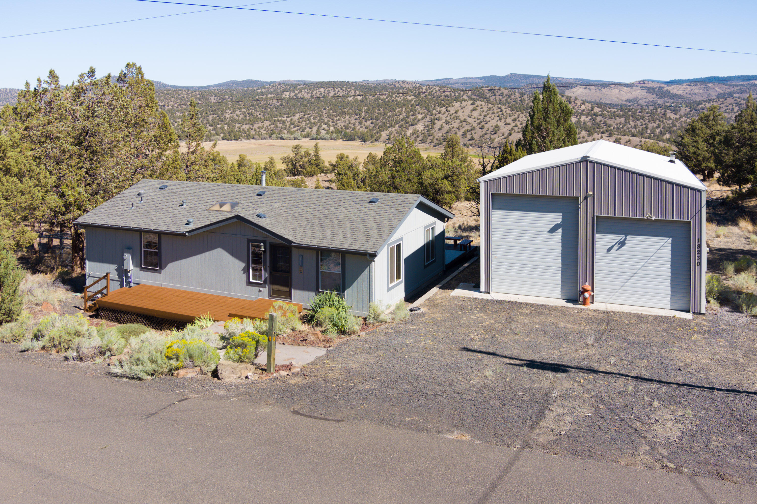 Amazingly clean and well-kept fully furnished single level home with a large two bay shop overlooking the Prineville Reservoir within a mile of the boat launch. The exterior and decks are newly repainted and stained and everything inside is in perfect condition. The home has a great room layout, breakfast bar, large primary suite, spacious guest bedroom, and a utility room with the washer and dryer included. The back deck is composite and has a hot tub right on the edge for ease of entry. The shop has a concrete floor, its own dedicated panel with room for 50 amp RV/EV plug, lights and plugs throughout, and an upstairs storage area. Next to the shop there is also outside RV parking. Additionally, below the house you'll find a shaded dog kennel with concrete floor. This property affords out the front door access to some of the best boating, fishing, ATV exploration, hunting, general outdoor activities, and light pollution free start gazing of any property available on the market today.