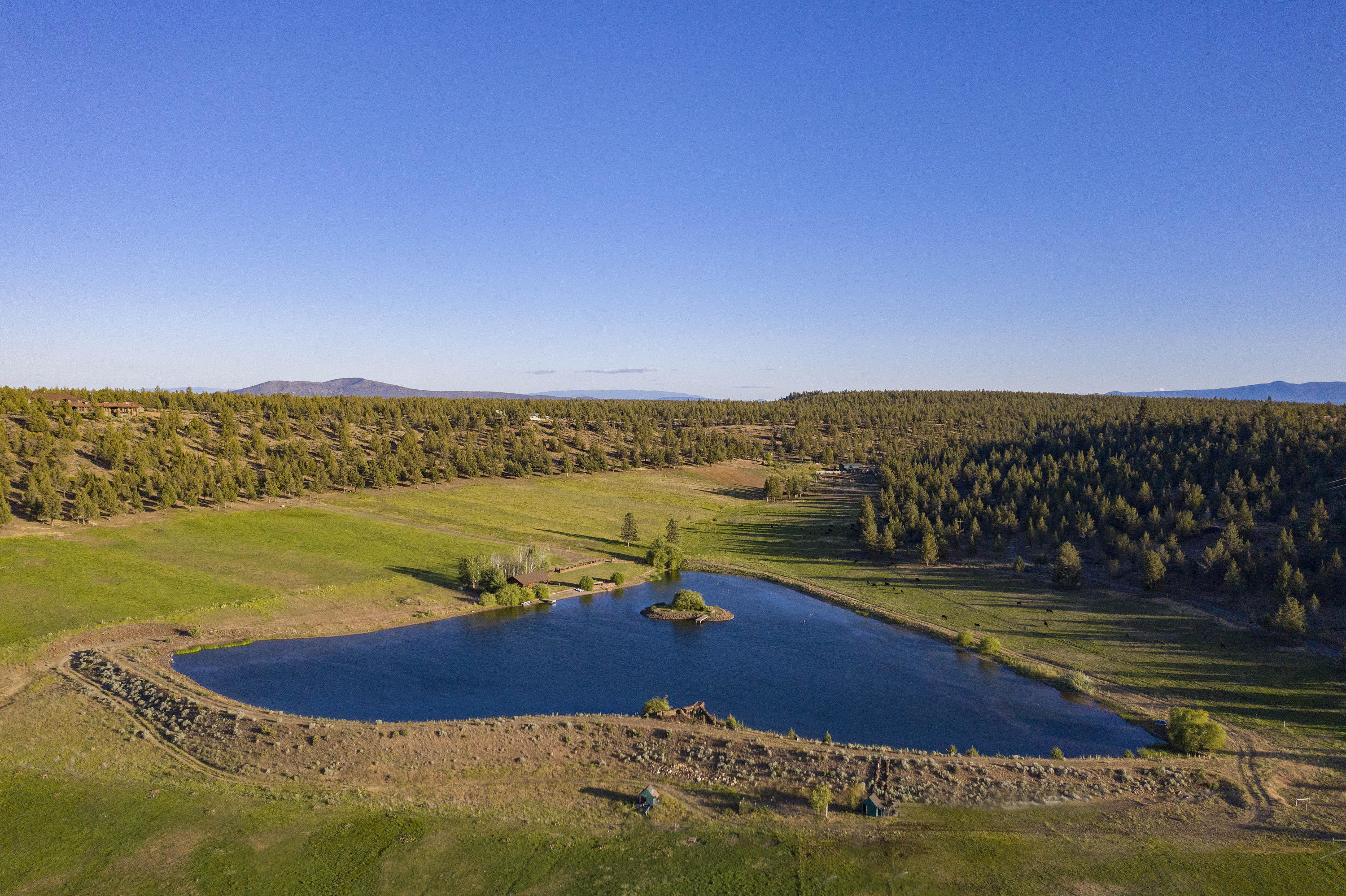 Incredible opportunity to own one of the most spectacular ranching and recreational properties in Central Oregon nestled in a private little valley of your own. Turn key cattle / horse operation, 138 acres with 63 acres of irrigation using buried lines and pop up sprinklers, fenced pastures, hay barn, and a shop. 6 acre lake is ready for your own private fishing, hunting, or water sports passions. A large pavilion with manicured lawn sits on the edge of the lake inviting your guests to celebrate the amazing view and sunsets next to the fire pit. Borders thousands of acres of BLM land. A 2 bed 2 bath manufactured home is on the property with electrical power to a new build site. Live in the existing home while you build your dream. 20 minutes from Sisters and 40 minutes from Bend. Only 30 minutes from the Redmond airport.  Ask listing broker for extensive property info. book.