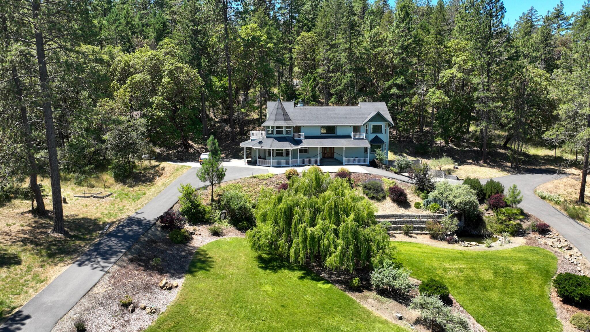 Country living minutes from Grants Pass, this grand home nestled on 5 acres is a must see! Spectacular views, spacious floor plan and a welcoming entrance to the foyer and stunning curved staircase await you. The kitchen offers granite counters, new appliances, custom cabinets with recessed lighting, abundance of storage and a large kitchen island. The master, located on the 1st level has 2 walk in closets, jetted tub and step in shower. Upstairs features an open area for entertaining, bedrooms on each side with balconies overlooking the valley. The office or possible 4th bedroom is located upstairs. Over 1600sf finished basement & add'l storage with access to the 2 car garage offers endless storage or shop space. The front yard is magnificently landscaped with lawn, stunning weeping willow tree and a 10' waterfall into a pond. Interior of home was recently painted & the hardwood floors resurfaced. Strong well per seller. All information deemed reliable but not guaranteed.