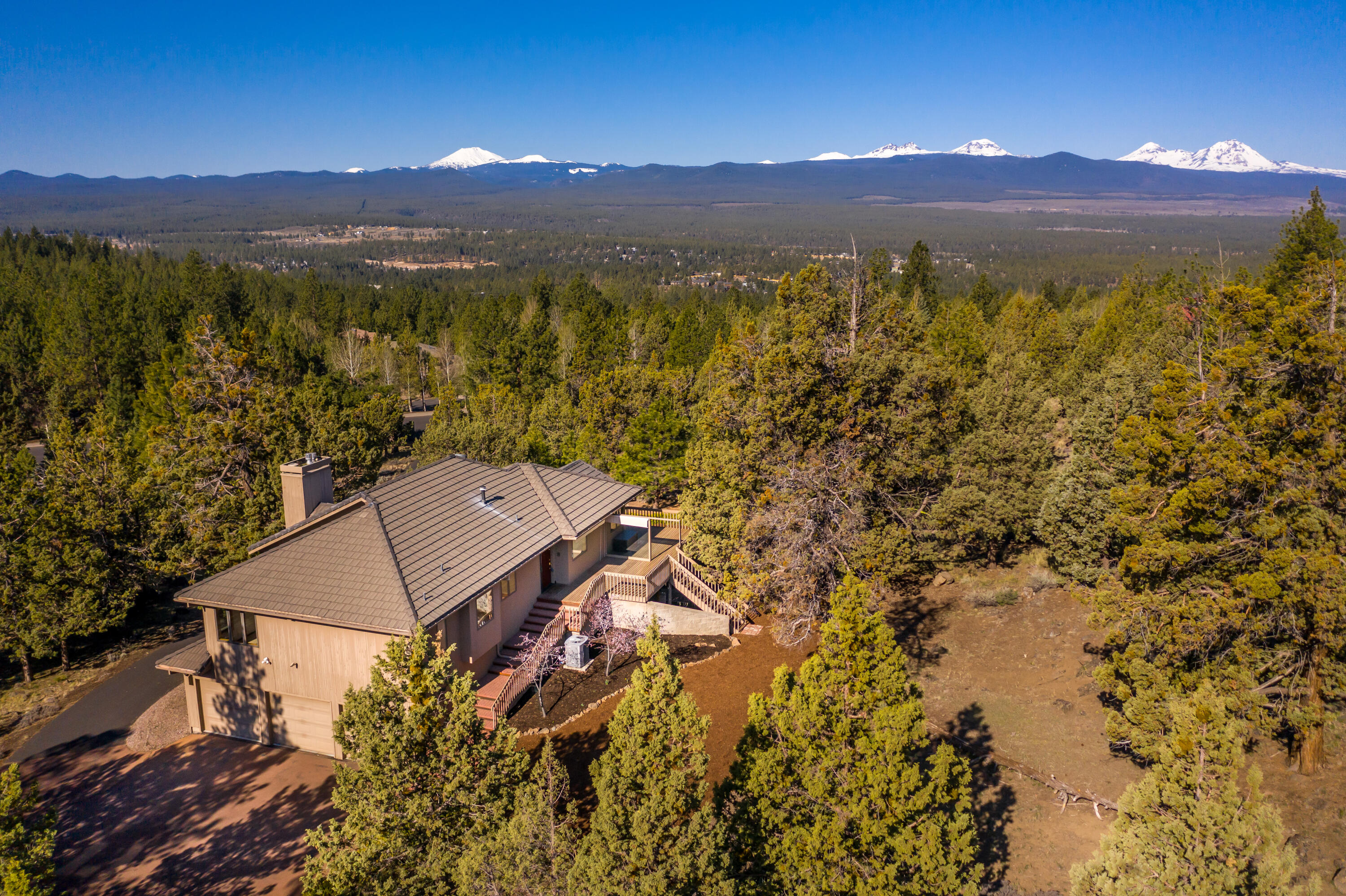 A unique opportunity to create a beautiful home on 2.2 acres of secluded Cascade view property at the top of Awbrey Butte, just minutes from downtown. Move-in ready, but with loads of potential! Sellers will be leaving Bend due to unforeseen circumstances, giving you the opportunity to do the major reno they had planned, enjoy the property as is, or truly make it your own. Copies of the original plans, as well as nearly complete reno plans by a leading architect, are included. As is, tranquil living begins on the Main floor which features a huge primary suite, office/bedroom, vaulted ceiling living room with fireplace and built-ins, kitchen, and dining area. Large deck for entertaining or relaxing. Downstairs area provides privacy and a private entrance for two guest rooms, full bath, laundry, along with two flex spaces with a gas stove. Abundant areas for storage indoors and out, wine cellar, and three car garage.