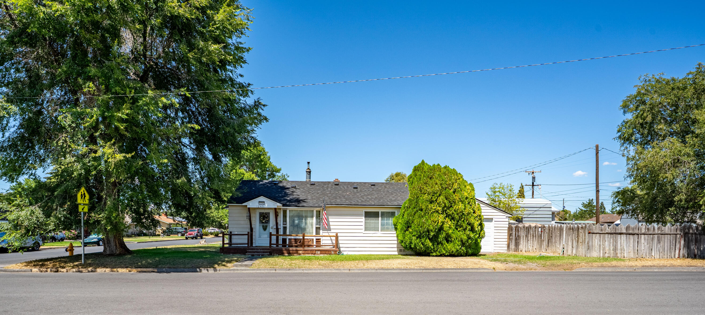 Charming 1954 built cottage ready for its next chapter! Situated on a .13 acre lot directly across from M.A Lynch Elementary School, and zoned R5 (great development potential) this home has so much versatility of use! The 876sf home boasts a vintage charm with its built in cabinets throughout, real hardwood flooring, and has 2 bedrooms, 1 bathroom, living room, formal dining, kitchen and laundry room. Living room offers bay windows with benches, ceiling fan, and a cozy freestanding gas stove with brick surround. Covered back patio, extended concrete patio, Hot Tub disconnect, 2 storage sheds, and a fully fenced yard with gates on either end of the property. Detached single garage is extra long, allowing for plenty of storage, and is equipped with a 30amp plugs for your RV. The central location, great lot size, main road and alley access allow for so much to be done on this property. Give the home a little TLC, add additional units... bring your dreams to life! Welcome home.