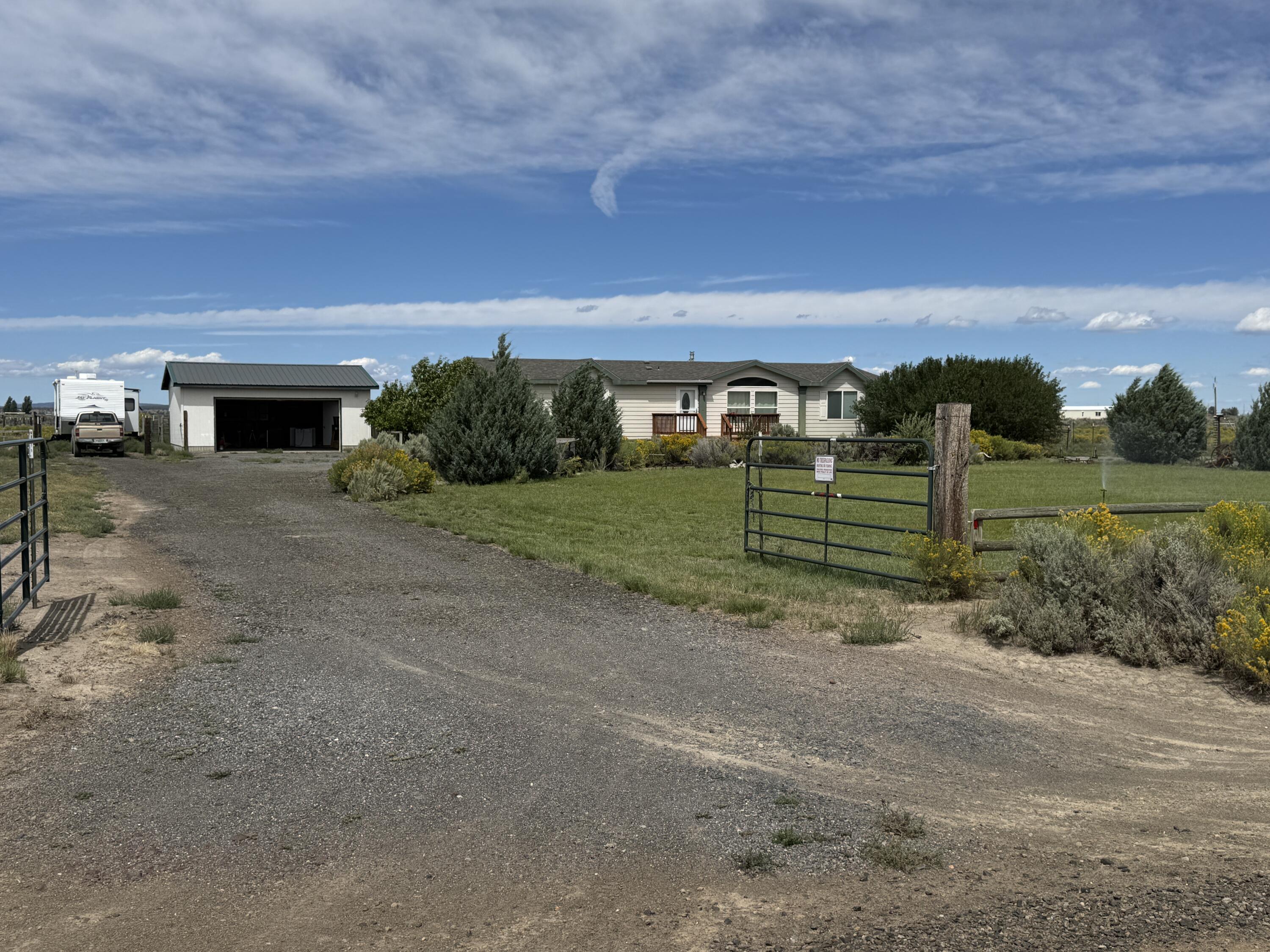 Spacious 3BD/2BA home on 2.44 acres with panoramic mountain views.  This 1880 sq ft triple wide manufactured home offers a bright, open floor plan  The kitchen features ample cabinetry, a large pantry, and an island that opens to both a dining room and a family room with a certified wood stove.  The primary bedroom features a walk-in closet and a primary bathroom with dual sinks, a vanity, soaking tub, and a separate shower.  Enjoy stunning mountain views from the beautifully landscaped property, complete with apple trees, a garden area, greenhouse, and a woodshed containing lots of seasoned firewood.  A fenced children's play area with a well built playhouse situated in the back yard with lots of green lush lawn to run around on.  Fully fenced and gated, this property also features a detached 2 car garage, circle front driveway, and gated RV parking.  Peaceful rural living within minutes of the quaint little town of Christmas Valley.