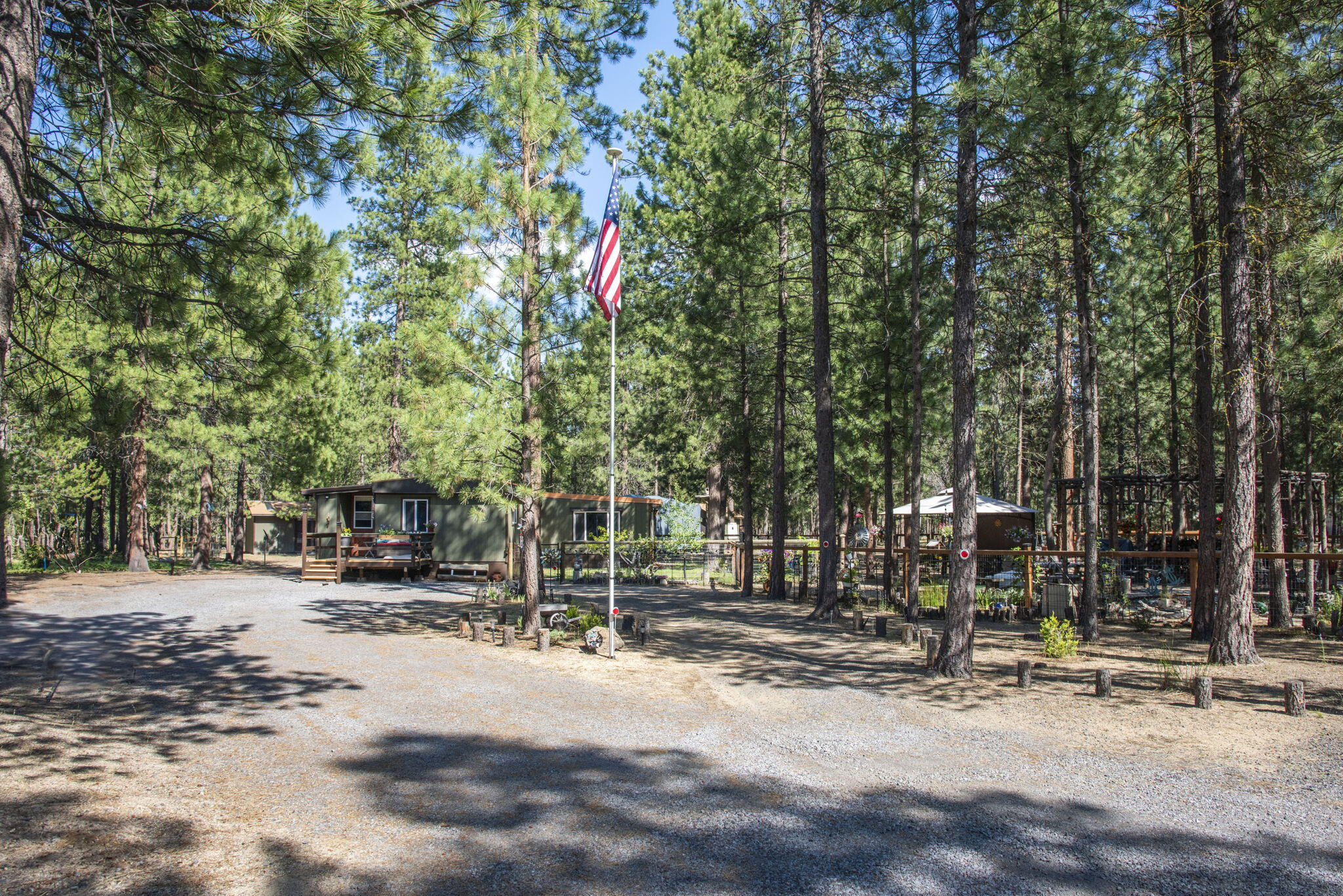 Tucked away on a cul-de-sac in Ponderosa Pines, this peaceful, forested property offers privacy and character. The well-maintained manufactured home includes a 225 sq ft finished addition, currently used as a 3rd bedroom, with ADA ramp access. Enjoy a covered front porch, new front deck, fresh exterior paint, and matching outbuildings. Interior upgrades include windows, electrical, lighting, plumbing, ventilation, paint and more! High-speed internet available! The fenced and cross-fenced yard features fruit trees, a serene pond, and covered seating. Includes a 1-car garage with large lean-to, 2 storage buildings, and RV parking—great for toys and hobbies. Many items stay—ask for a list! HOA includes community water. The addition has a recent inspection, and the home qualifies for VA and Conventional financing. This is a must-see and then a must-have property that has been lovingly updated.