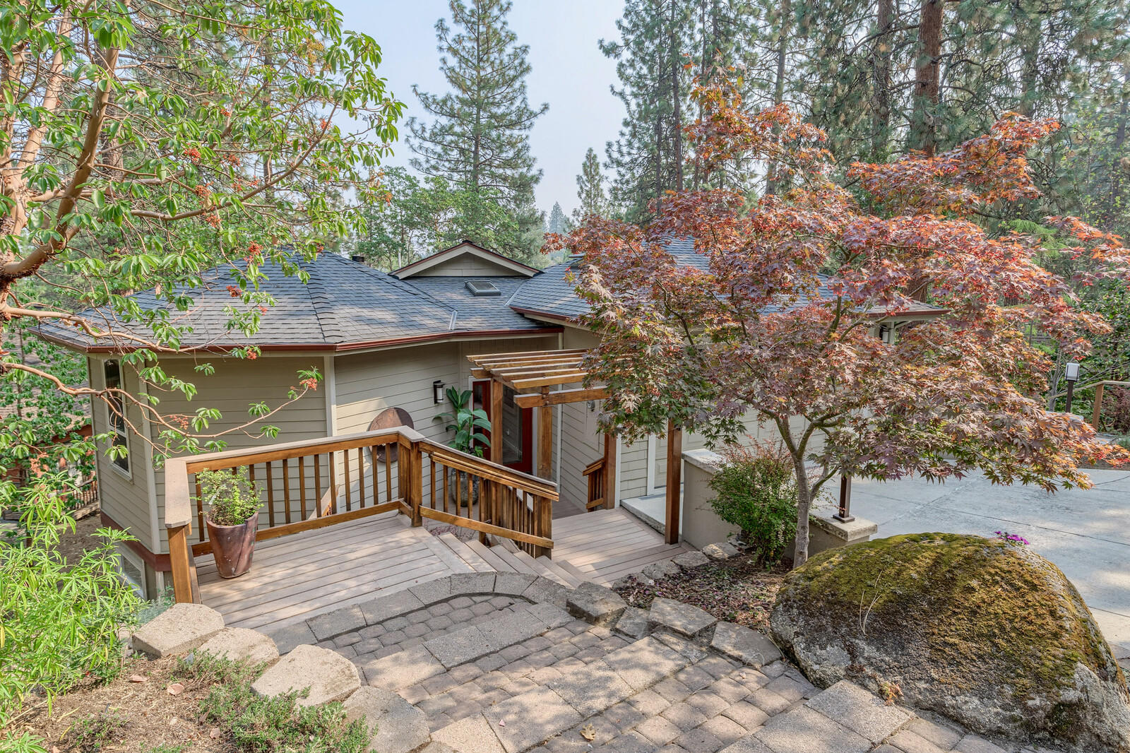 Quality built contemporary home placed among the madrone and pine trees in the hills of beautiful Ashland OR. Versatile, user friendly floor plan with many unique architectural features. The cozy living room w/ fireplace, kitchen and dining area surround a well-designed multi use pantry closet. Soaring open beam ceiling above leads to a wall of windows allowing for natural light and views of the trees and mountains afar. Two spacious decks to enjoy the natural setting. Main level has an incredible artistically designed room with spoke pattern beam ceiling, custom lighting, handcrafted shelving and a full bathroom. Lower level you will find a large spa like master bedroom suite w/ private patio, attached office/ reading room with access to the lower deck. Master bath has double vanities, a jetted tub and radiant heat floors. Two add'l bedrooms, full bath and laundry room are also on lower level. Perfect for the outdoor enthusiast w/ hiking trails just a few feet from the front door.