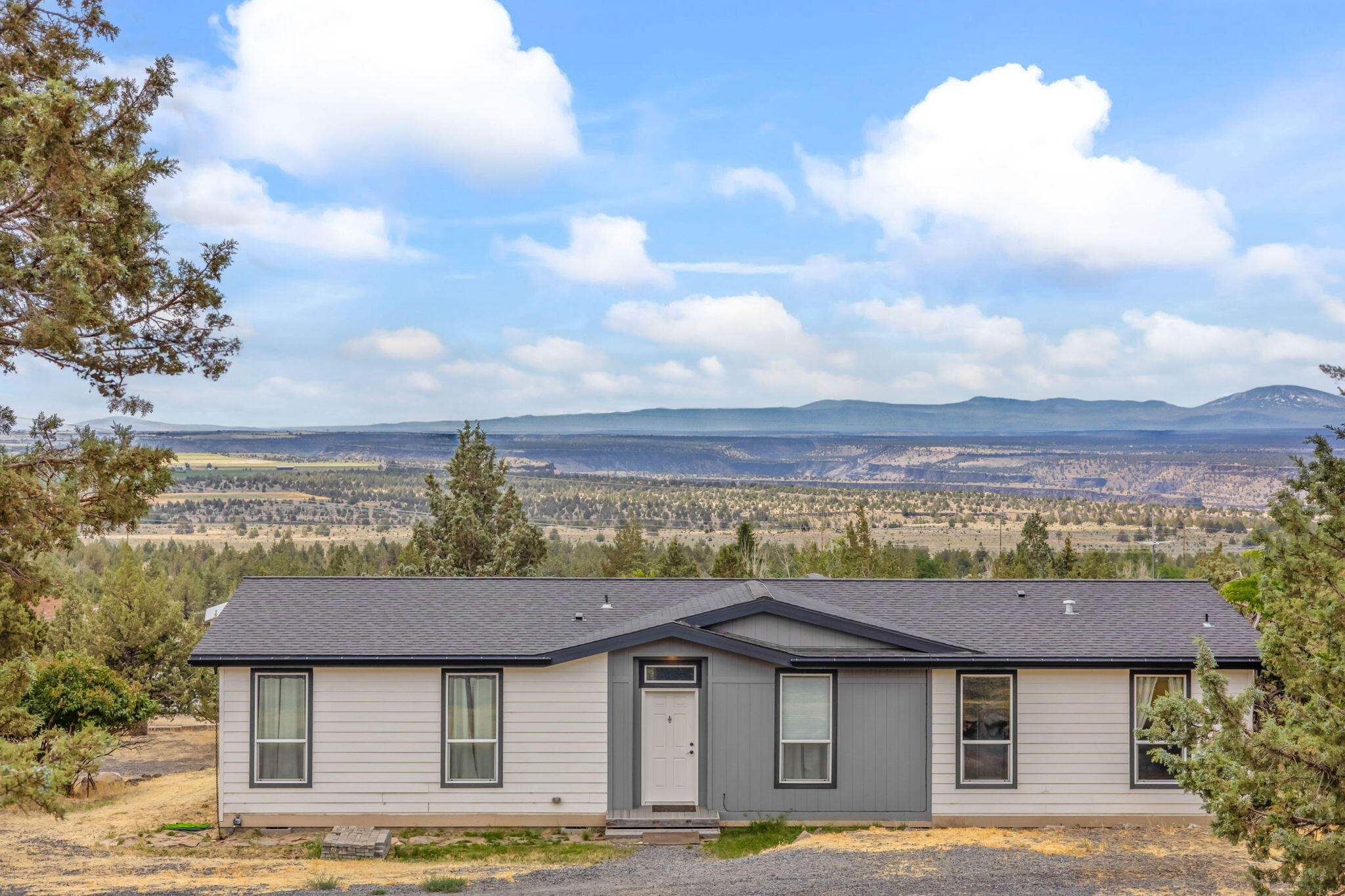 Imagine relaxing, sunbathing or dining on your covered 15X20 custom deck with extraordinary views of the beautiful Cascade Range.  Take advantage of the spectacular views, as well from the inside of the house with its many large windows!!  This home is custom-designed with a spacious floor plan with many upgrades including the carpet ''sinkoloy'' clay fired kitchen sink.  Plank flooring, high quality custom accordion shades.  It is equipped with a garbage disposal system, kimmer switches on lights, two extra doors on the back and side of house.  You will enjoy the additional interior custom wood trim including sliding ''barn doors'' into the office/bedroom.  The home is located in the Round Butte Recreational area just a short, six mile,  drive to Lake Billy Chinook.  If you love fishing or boating this place is for you!!!