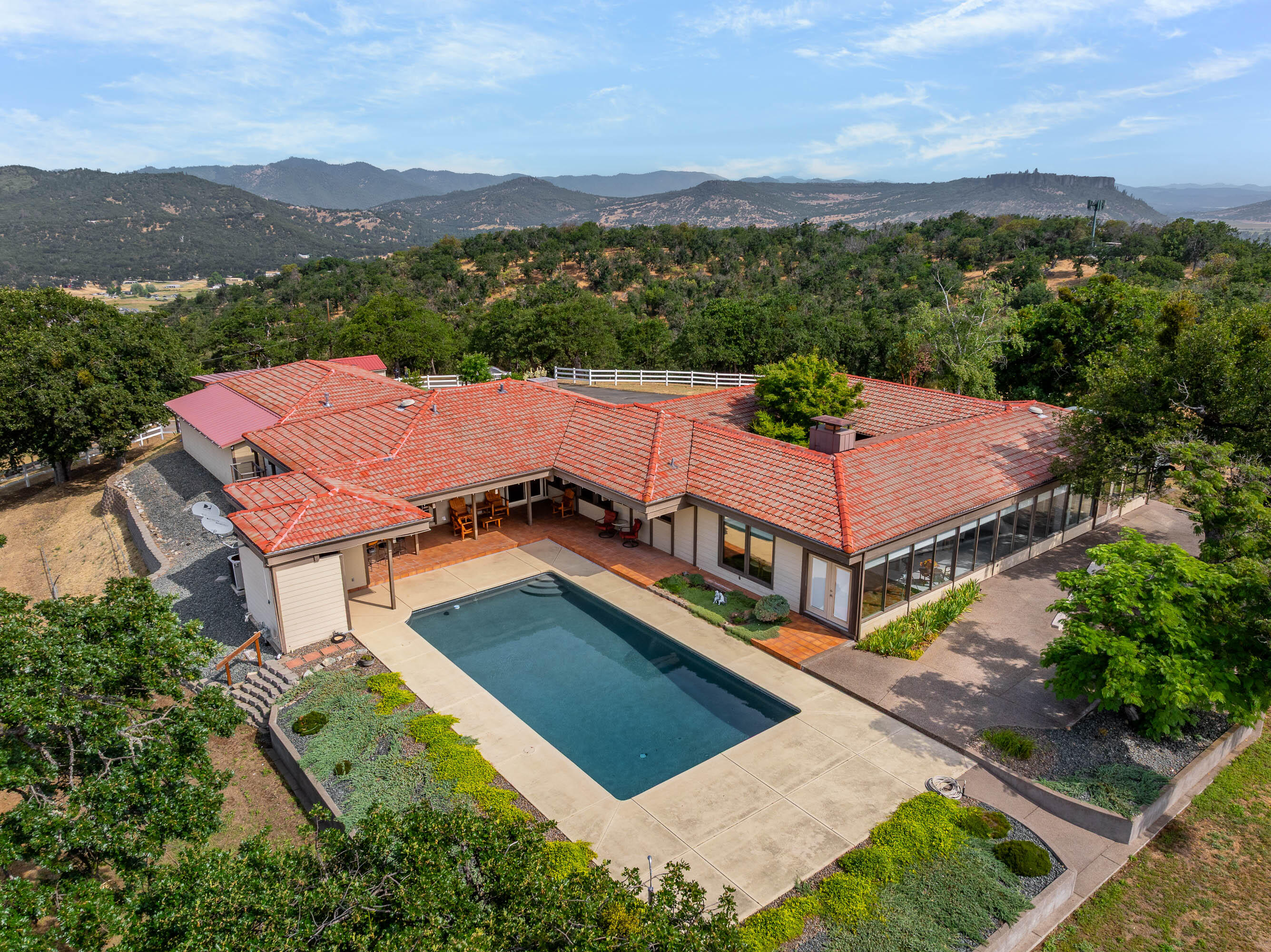 Mid-century modern elegance perched atop 20.36 private acres with breathtaking mountain and valley views!This stunning 4-bedroom,4-bath home features clean architectural lines,a unique indoor atrium that brings the outdoors in.The spacious kitchen has upgraded Thermador appliances and a view of the patio and pool so you don't miss the fun while cooking! The open living area is perfect for entertaining, flowing seamlessly to an incredible outdoor space with an inground pool, outdoor kitchen and spacious patio-deck. The luxurious primary suite offers a jetted tub, walk-in stone shower, dual vanities and a generous walk-in closet. The 1424 SqFt,  3 car finished garage with 3 phase power and added separate storage space will meet all  your storage and car needs.  With abundant RV parking and ultimate privacy, this one-of-a-kind property blends sophistication,comfort and natural beauty-your own mountain-top retreat awaits!