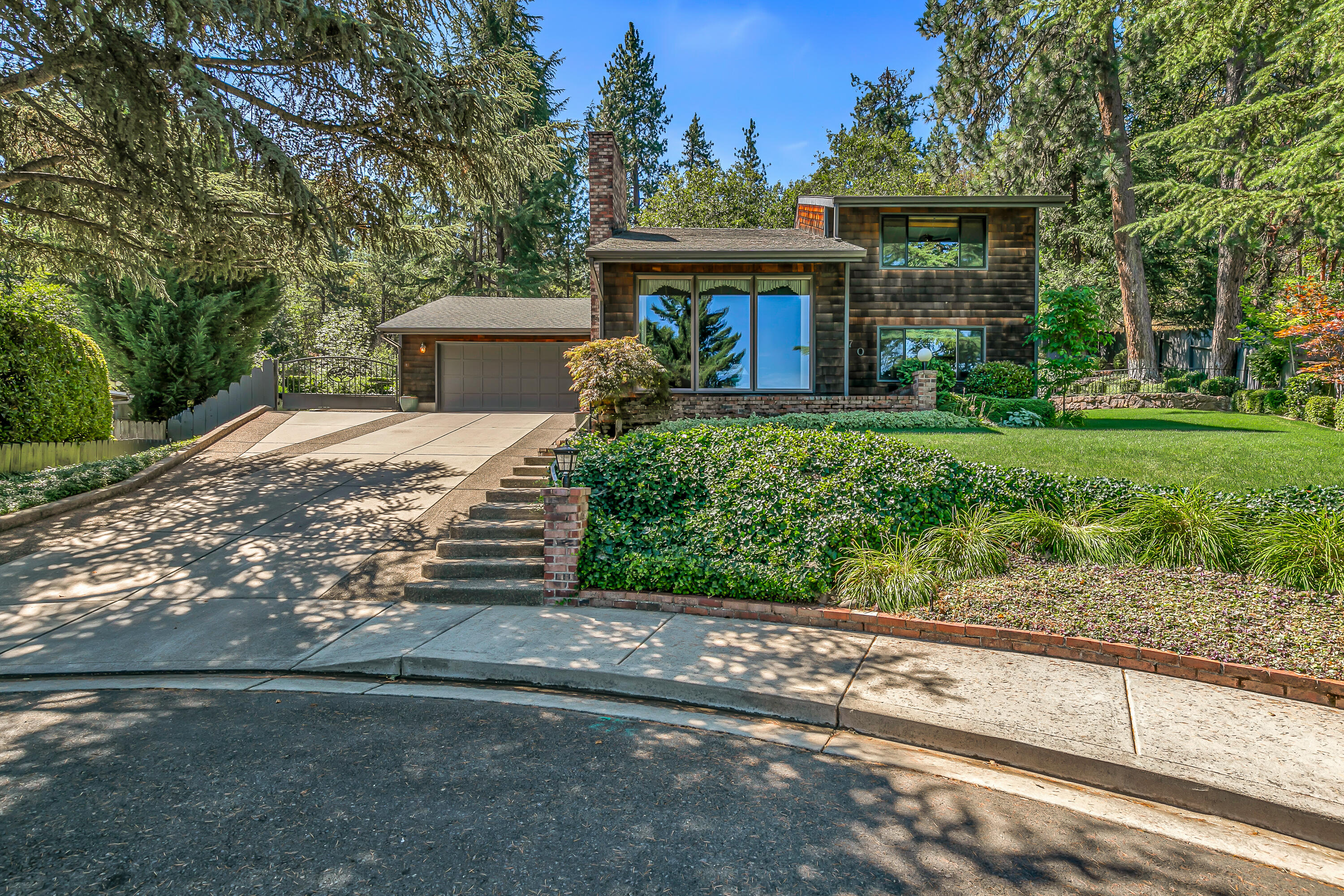 Enter into your own private oasis in one of Southern Oregon's most sought-after towns — Jacksonville. Thoughtfully maintained with exceptional pride of ownership, this 3-bedroom, 2-bathroom home offers 1,648 sq. ft. of inviting living space. Nestled on an elevated lot at the end of a quiet cul-de-sac, large windows frame serene views of a peaceful street just minutes from historic downtown. The beautifully landscaped backyard has been artfully designed by a professional horticulturist, featuring a tranquil water feature, abundant fruit trees, and flourishing garden beds — all blending seamlessly with the sounds of nature. A private gate at the rear of the property offers direct access to the scenic Beekman Arboretum & Trail system. This home offers the perfect blend of privacy, comfort, and charm. Truly a must-tour to appreciate its full beauty.