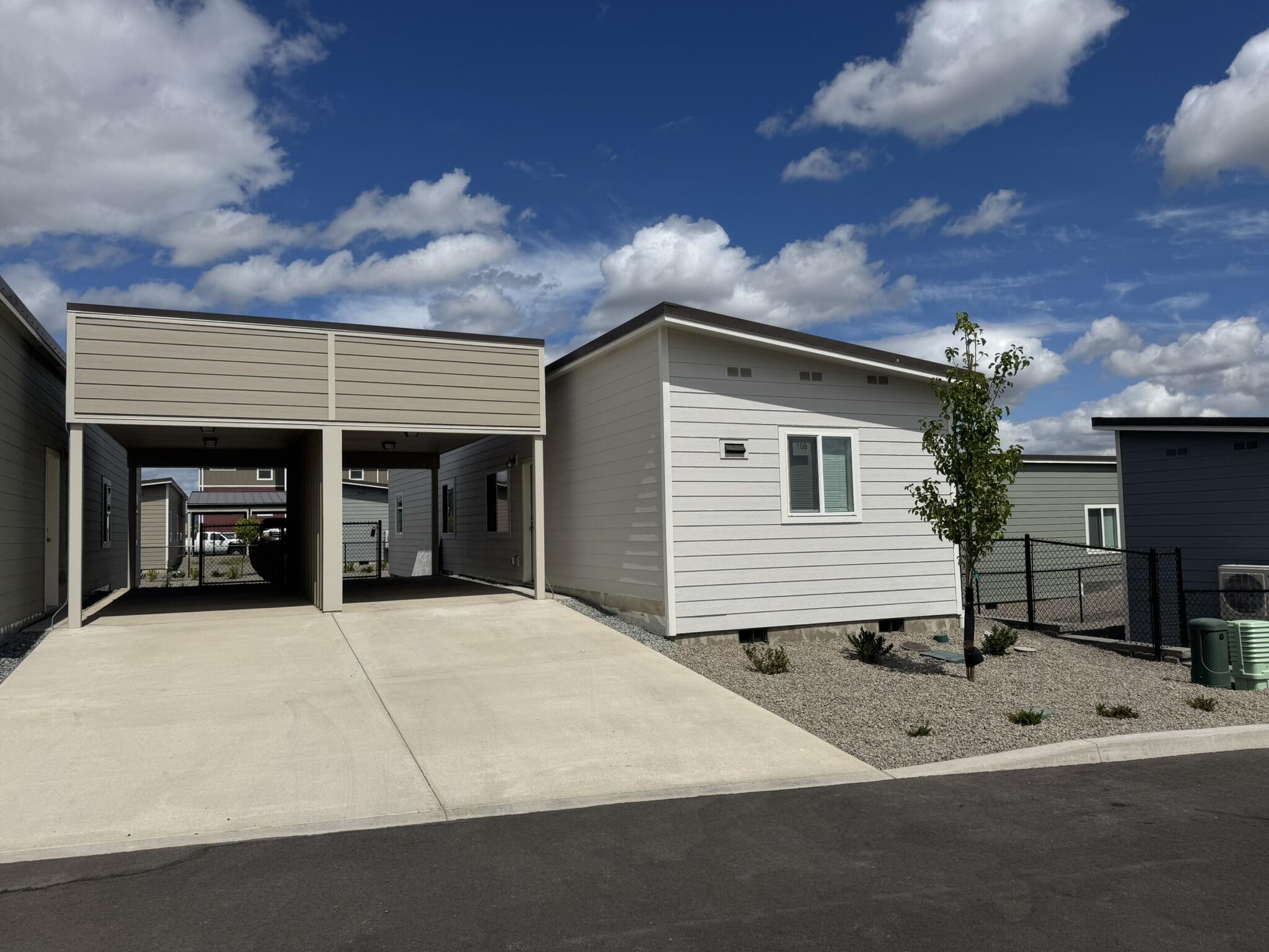 Welcome to your beautiful modular home, built in 2025, nestled in an all-ages park that offers both comfort & community. Featuring a stunning metal roof & durable vinyl plank flooring throughout. Boasting an open kitchen w all appliances included. Stay comfortable year-round w heating & AC mini-splits in each bedroom & the great room. The north-facing fully fenced backyard provides a shaded retreat, ideal for relaxing on warm sunny days. Plus, w a convenient carport, you'll never have to worry about parking. For just $700 per month, your park rent covers water, sewer, garbage, & gives you access to an amazing new kids' playground & clubhouse. This fantastic feature makes it easy to keep your little ones entertained while fostering a sense of community w your neighbors. Located just a short drive from restaurants, shopping, & freeway access, everything you need is right at your fingertips. Don't miss out on this incredible opportunity to own a lovely home in a vibrant community.